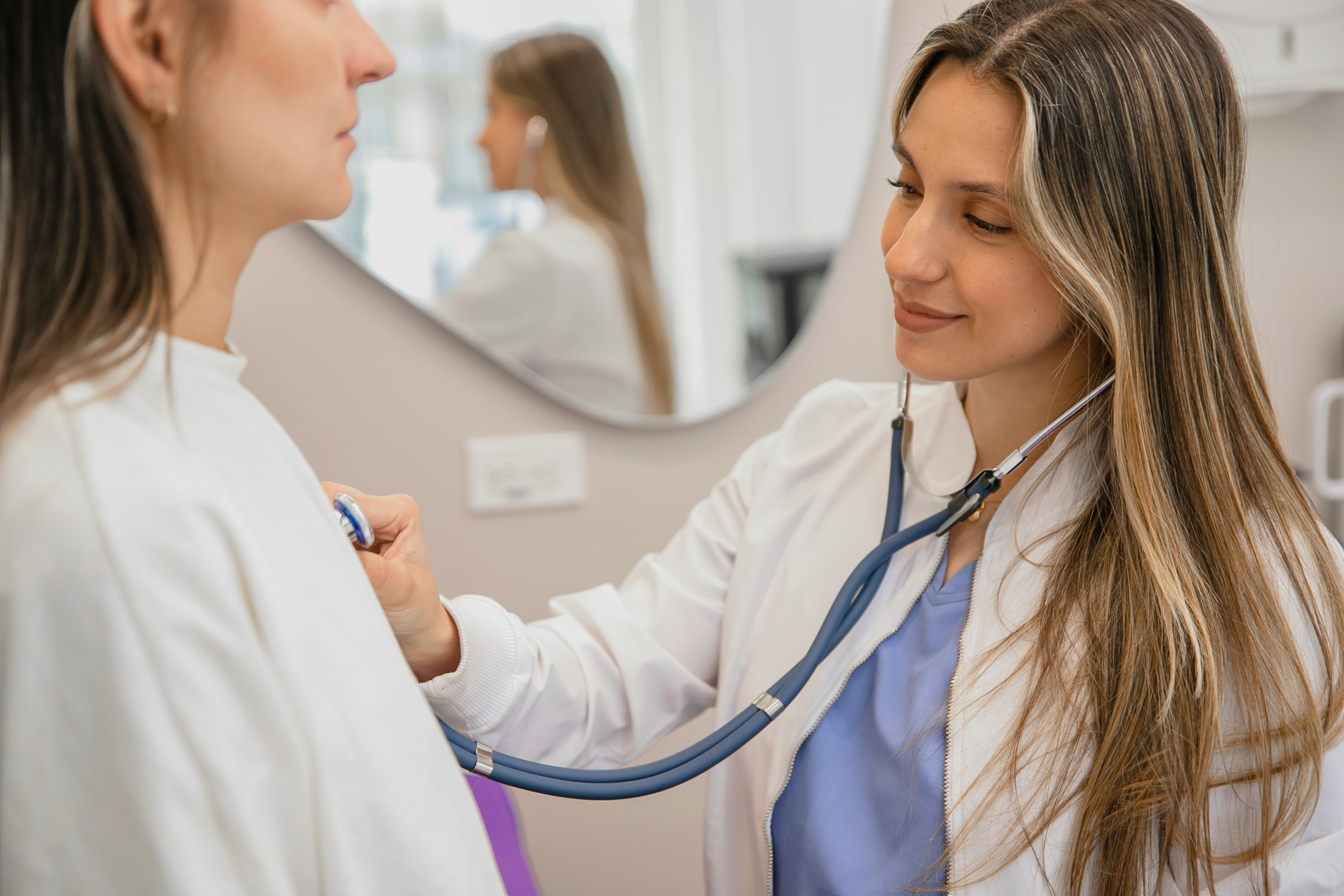 Healthcare professional using a stethoscope on a patient