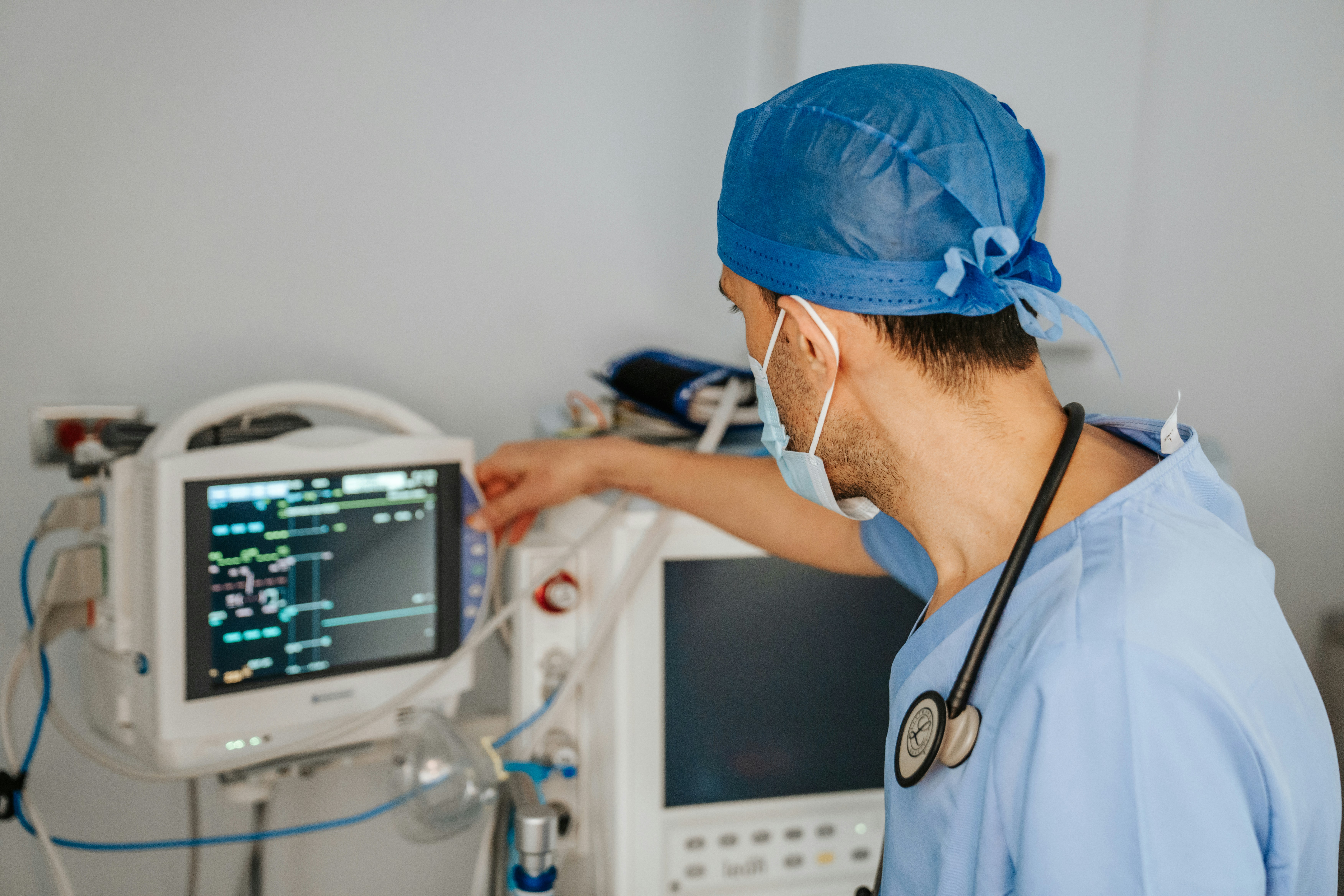 Healthcare professional in scrubs monitoring a medical device screen