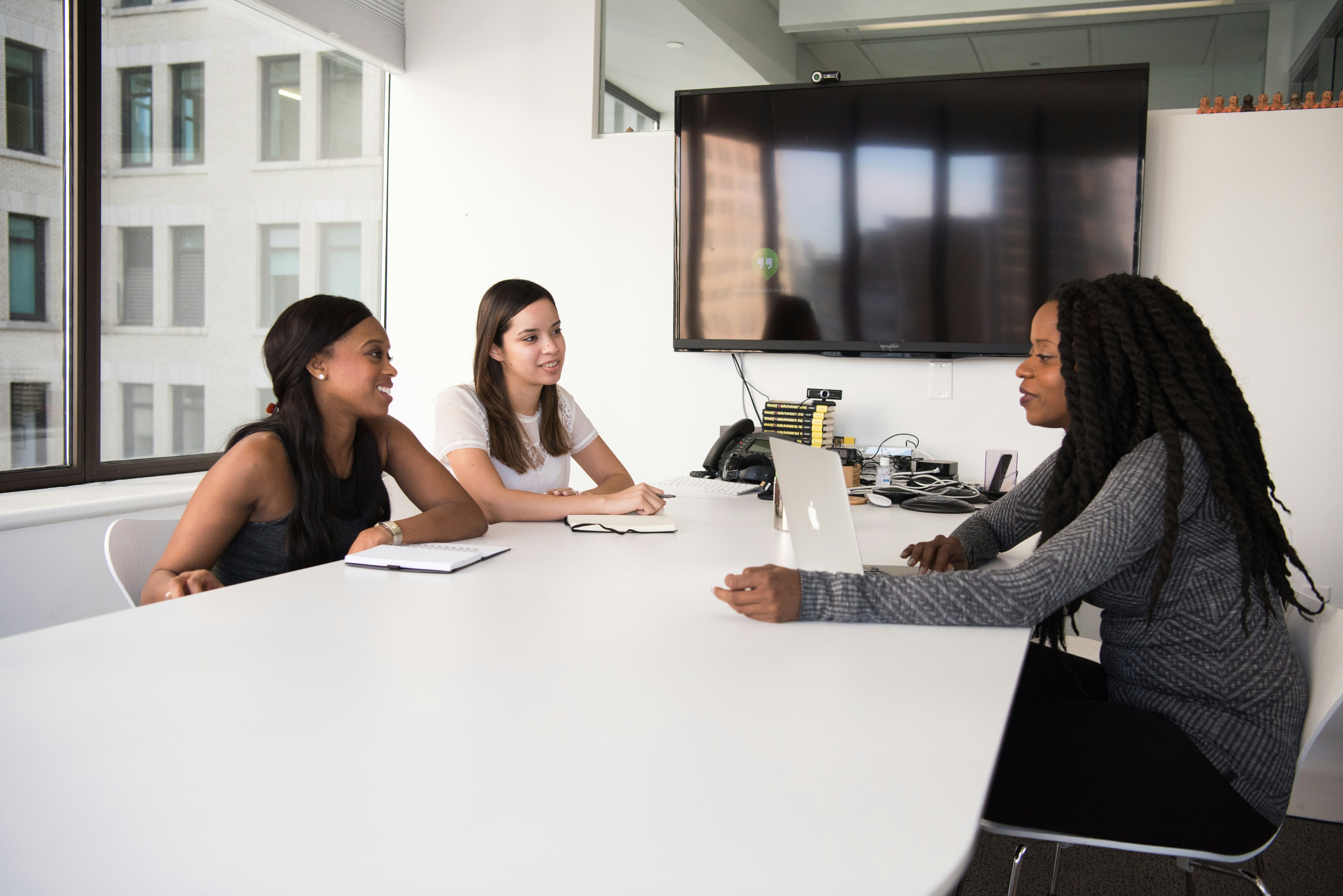 Three women having a meeting in a modern conference room.