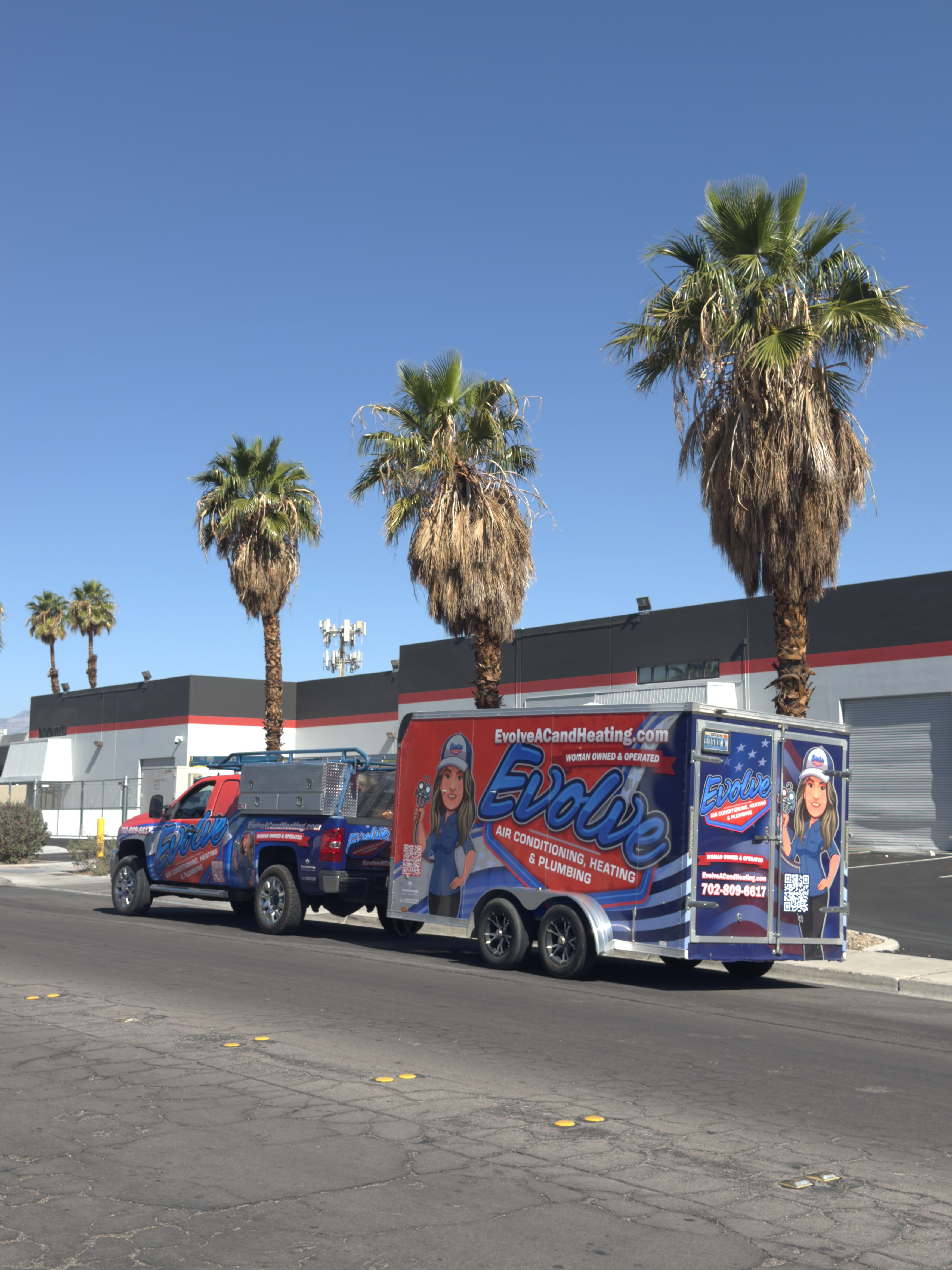 Evolve Air Conditioning truck and trailer parked on a street with palm trees