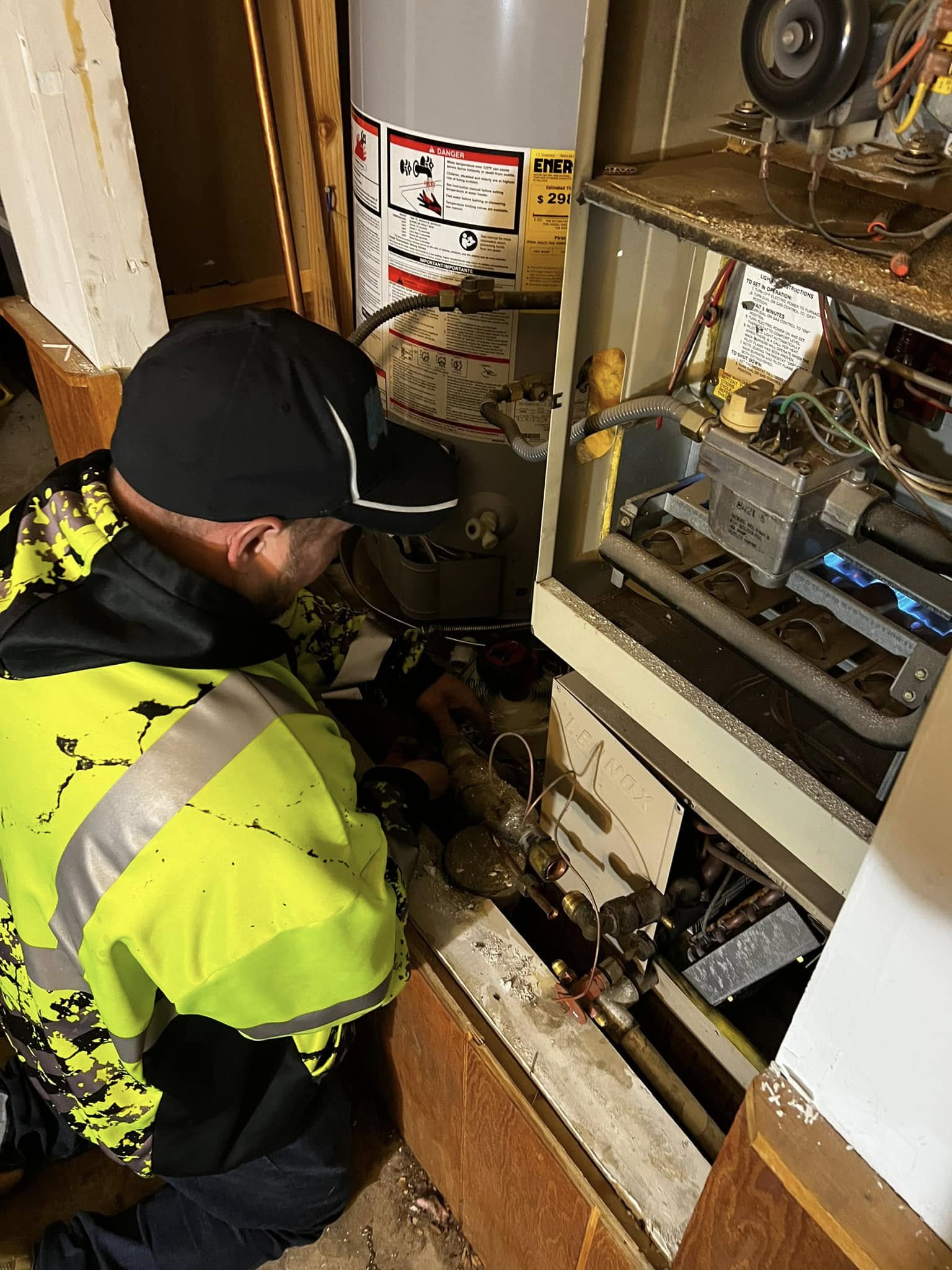 Technician adjusting settings on a heating system in a basement