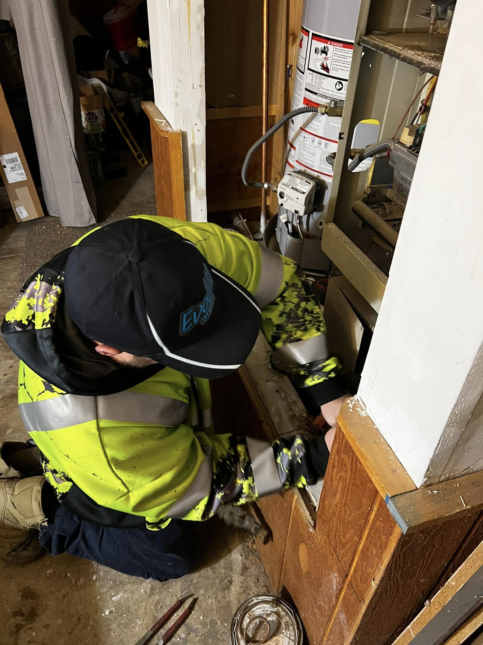 Technician in high-visibility clothing repairing a heating system