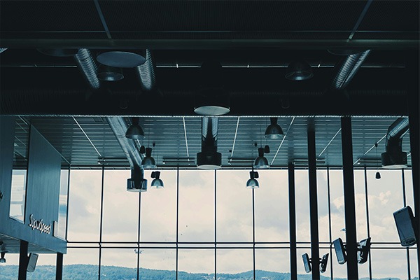 Interior view of a modern building with large windows and exposed ductwork