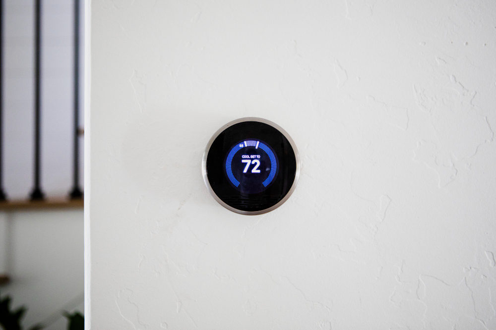 Smart thermostat displaying a temperature of 72 degrees on a white wall