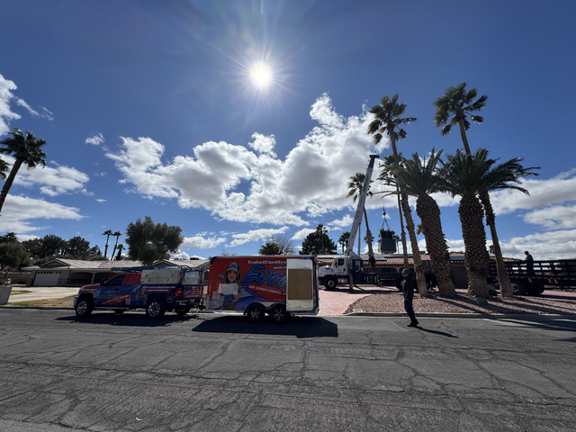 Evolve Air Conditioning truck and trailer parked on a sunny residential street with palm trees.