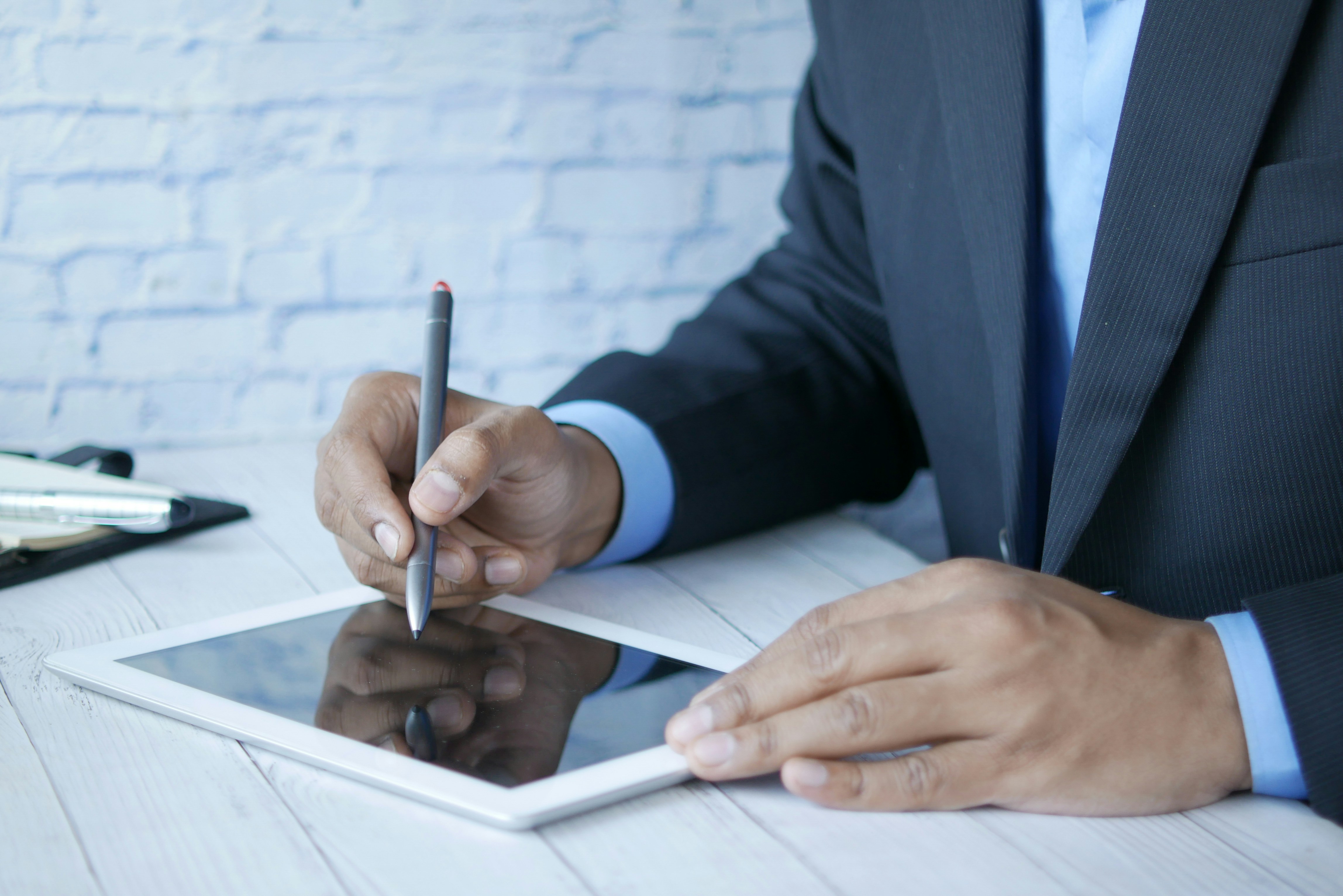 Two people discussing documents at a table with a laptop in a bright office