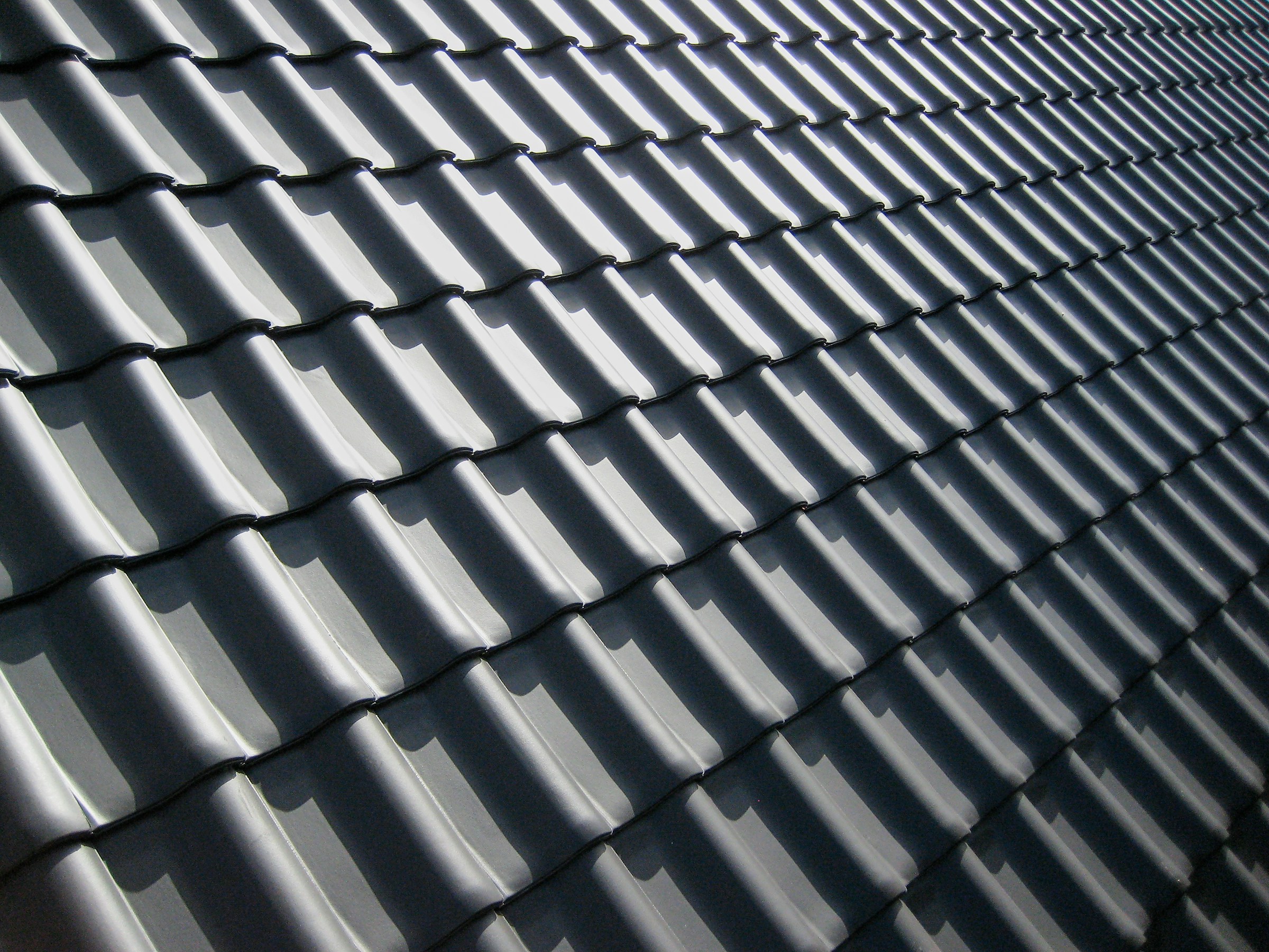 Close-up view of a metal tile roof with a wavy pattern