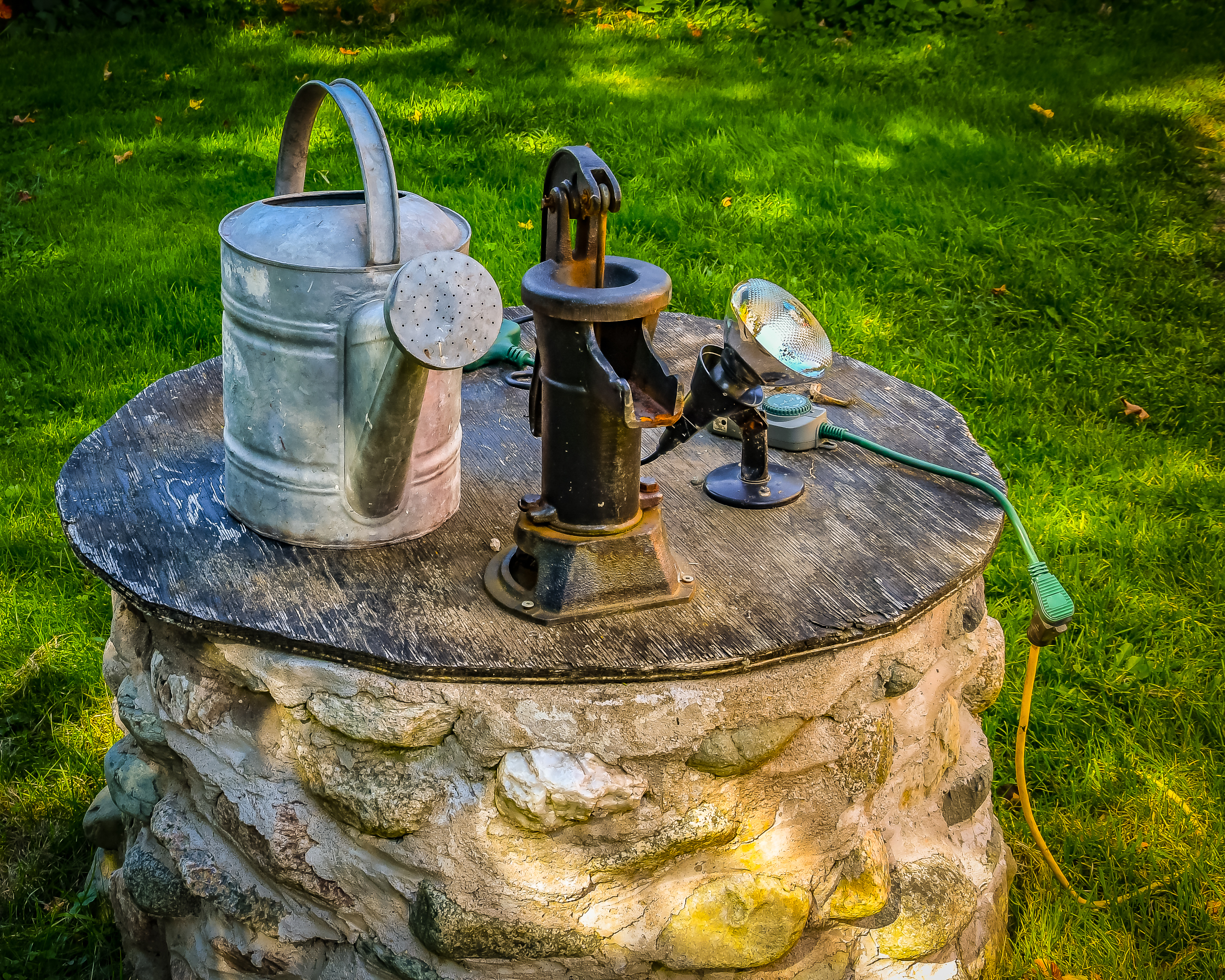 Outdoor plumbing pipes and valves with blue handles beside a wall