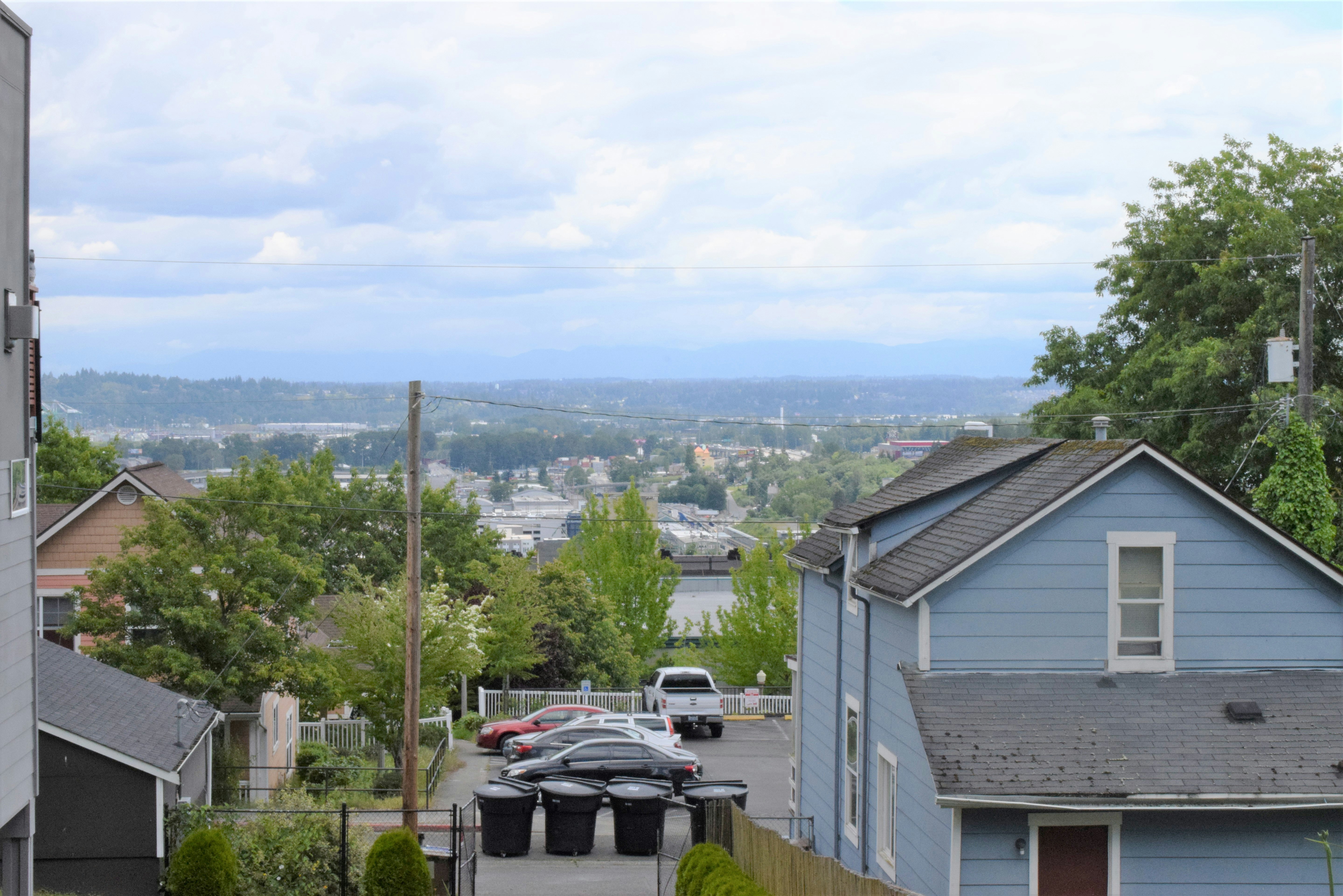 Residential neighborhood with view of distant cityscape and cloudy sky