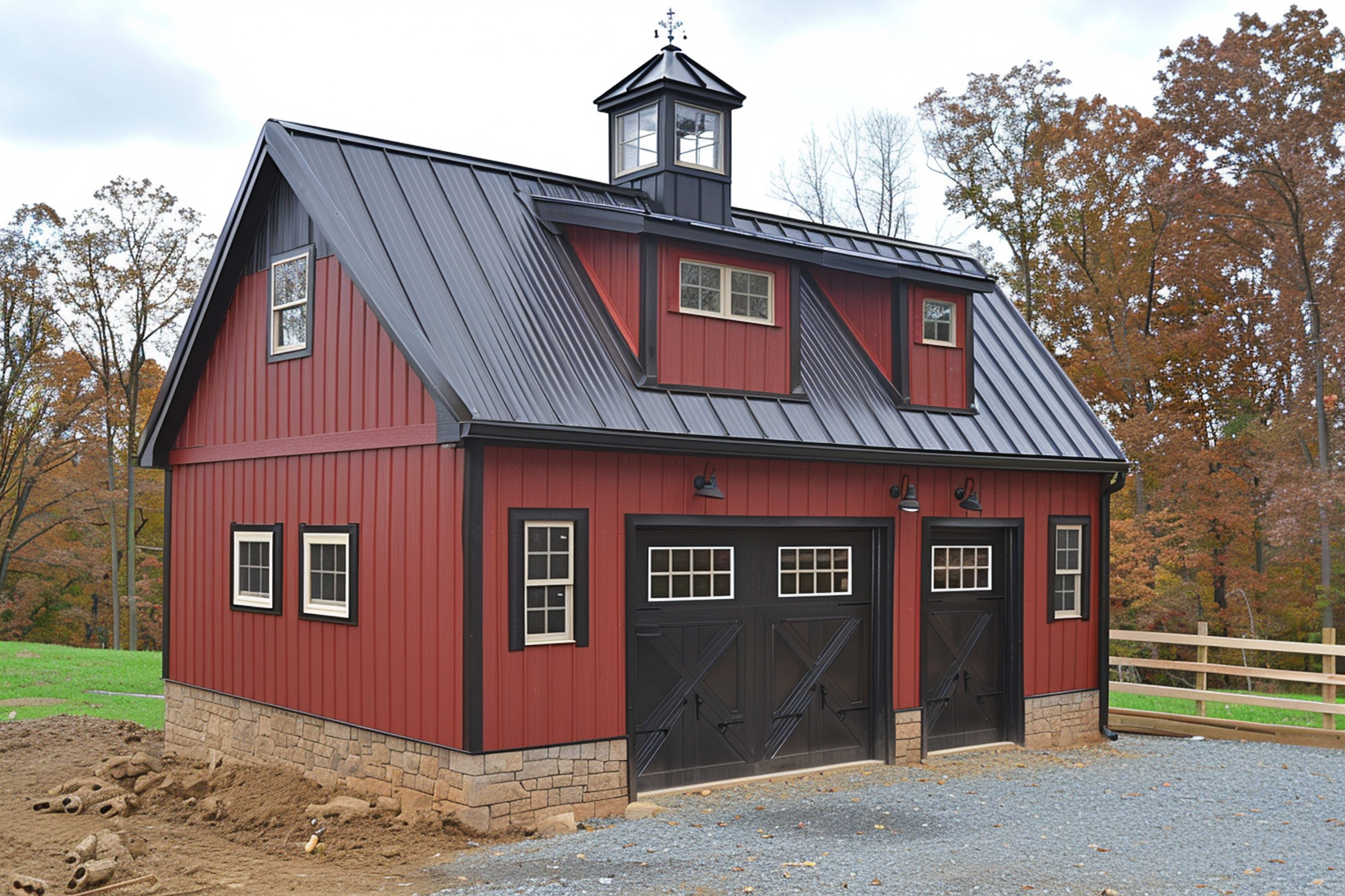 Red barn-style garage with black metal roof and two large doors