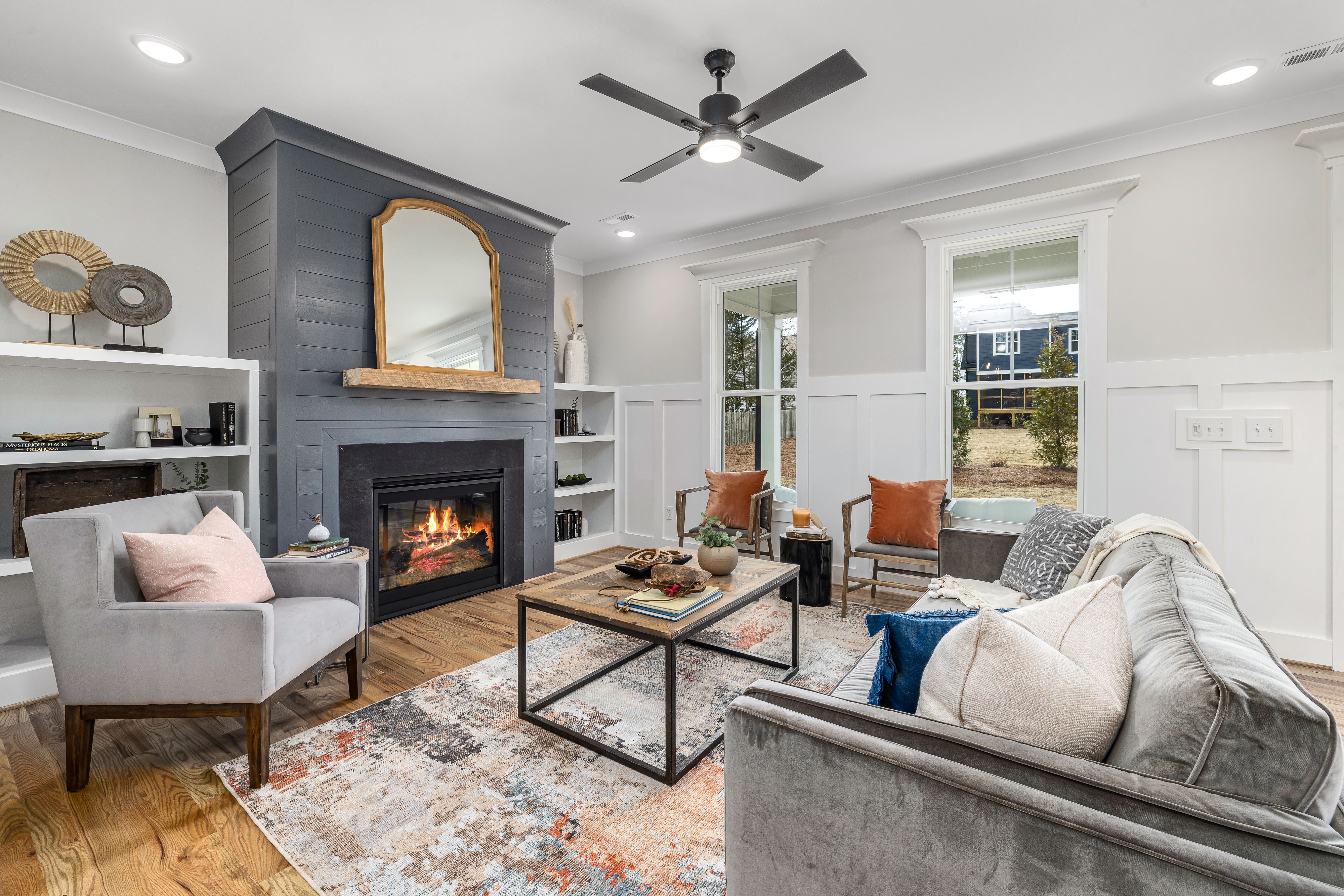 Modern living room with fireplace, gray sofa, and decorative shelves