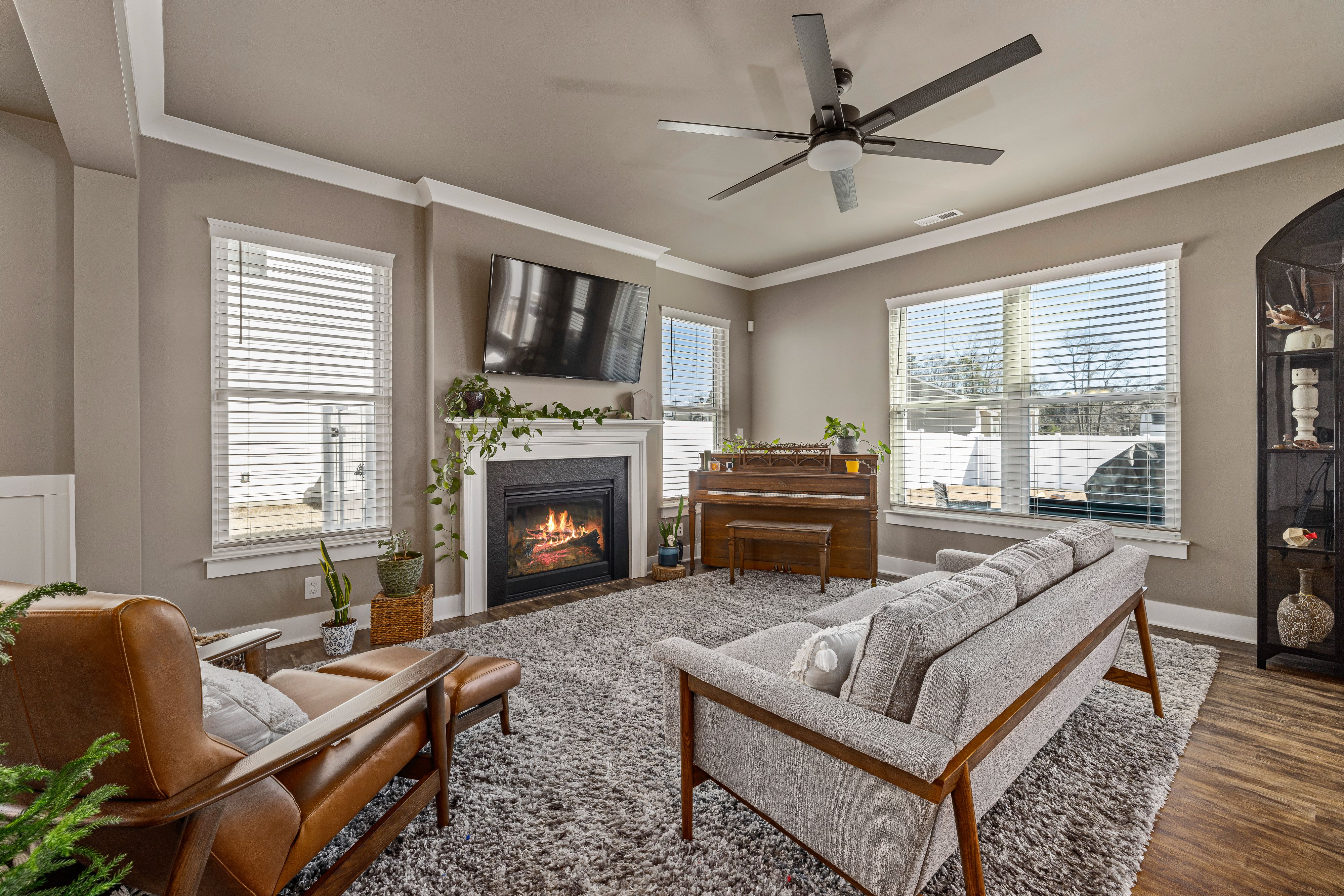 Modern living room with fireplace, sofa, armchair, and large windows