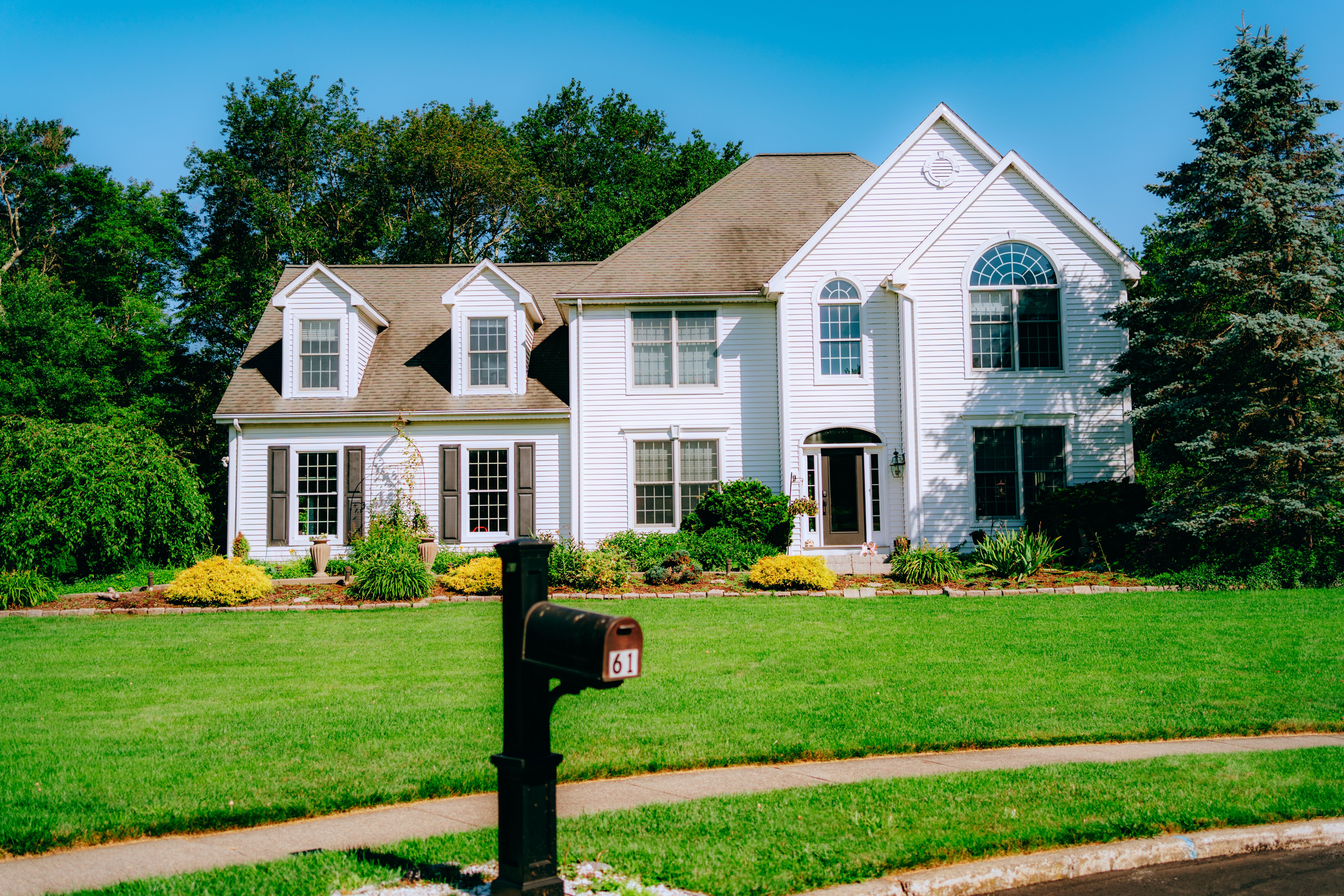 Large suburban house with manicured lawn and mailbox in front