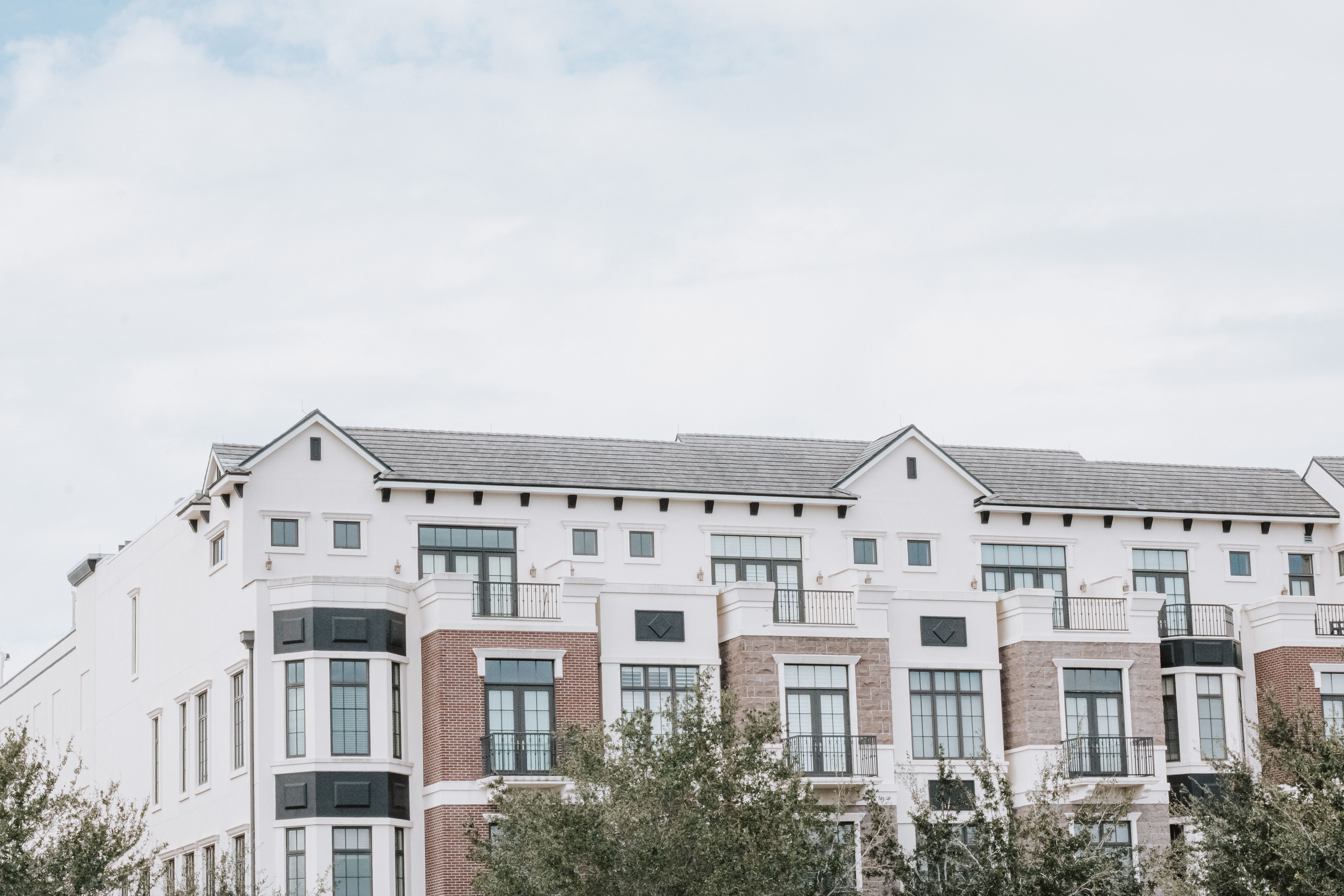 Modern multi-story residential building with balconies and large windows