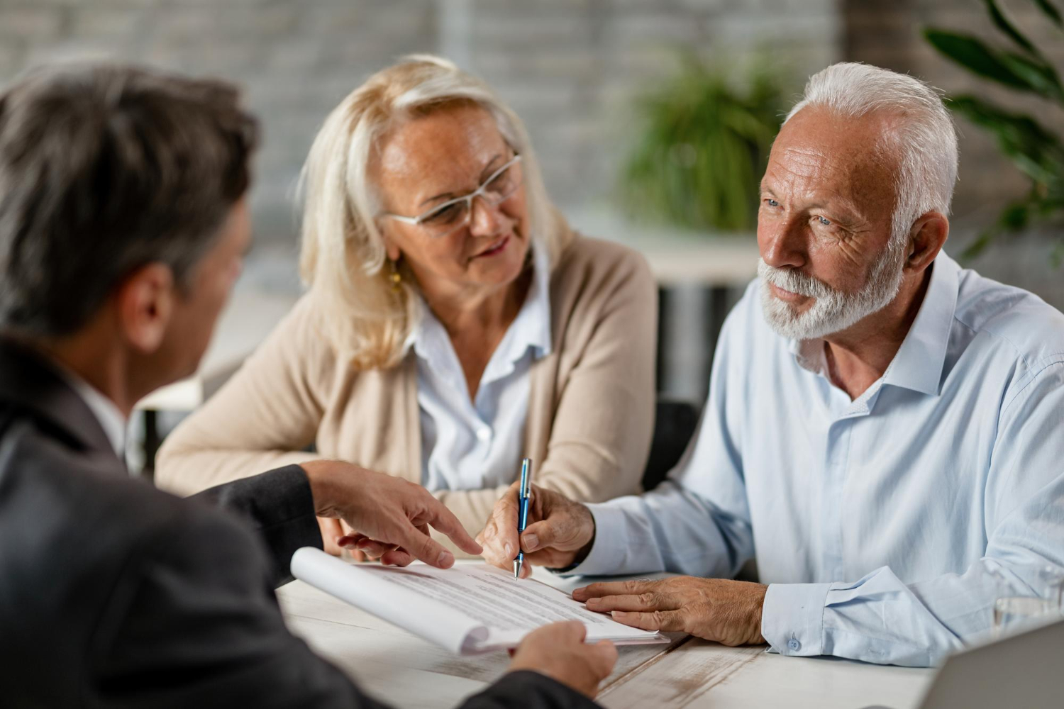 Two people in a bright office discussing documents across a desk