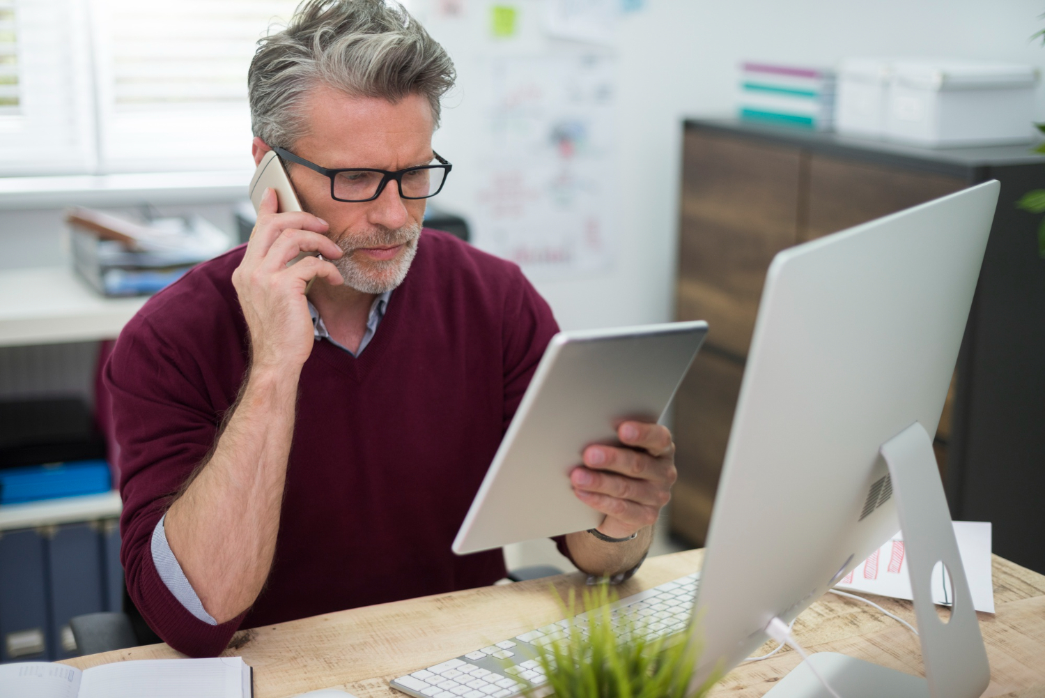 Two people in a bright office discussing documents across a desk