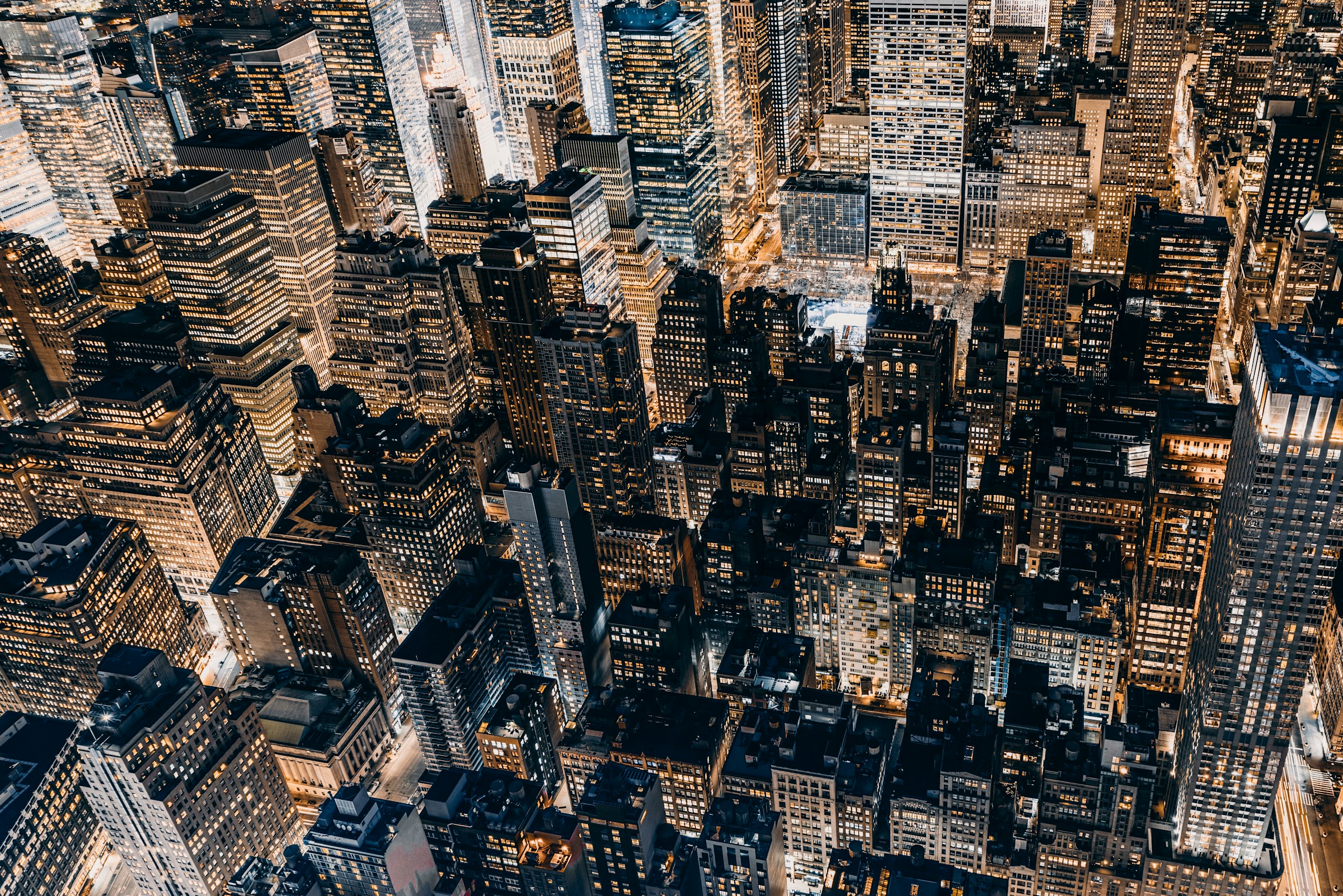 Aerial view of a cityscape with illuminated skyscrapers at night