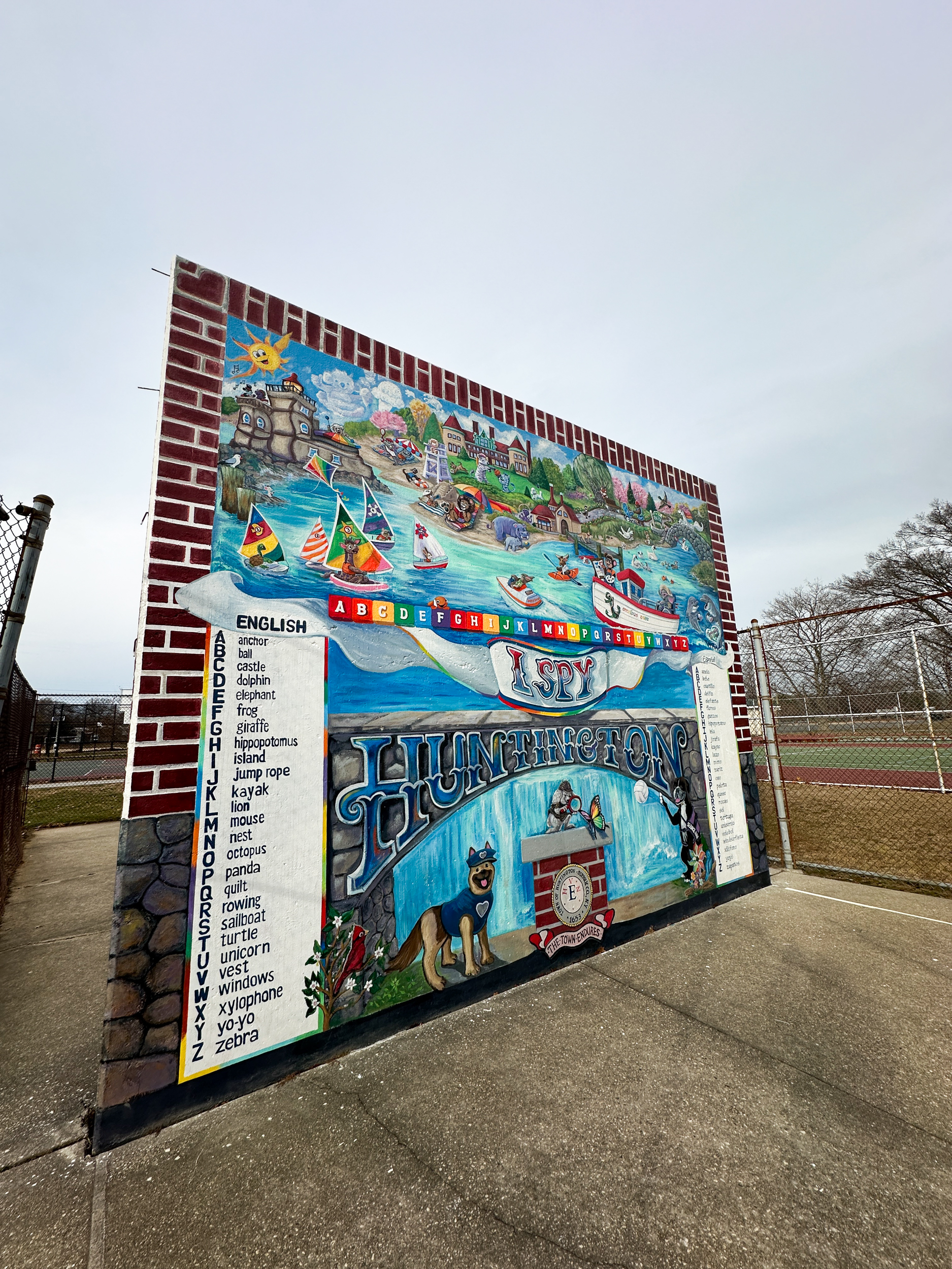 Colorful mural on a brick wall with alphabet and various illustrations.