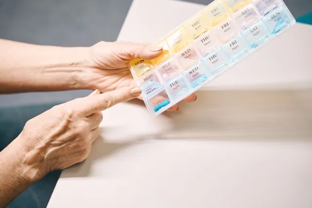 Hands stacked together with a healthcare provider in the background.