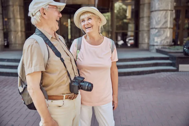 Hands stacked together with a healthcare provider in the background.