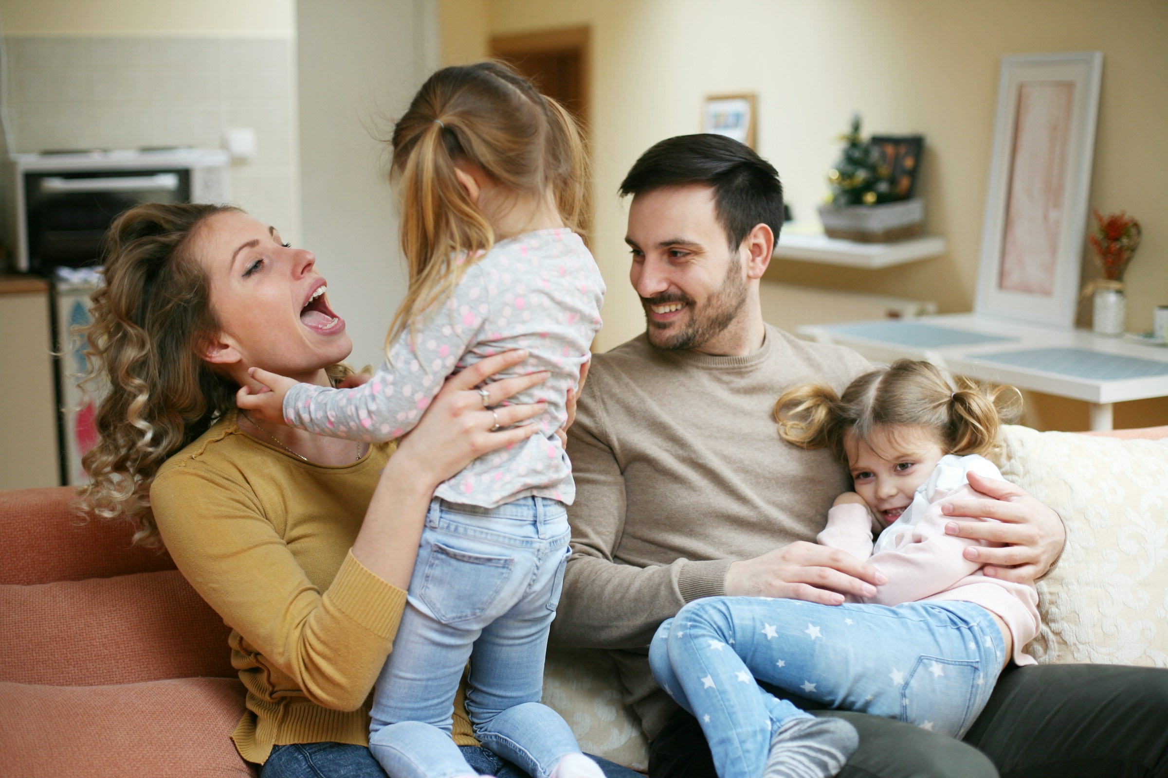 People loading a potted plant into an open car trunk