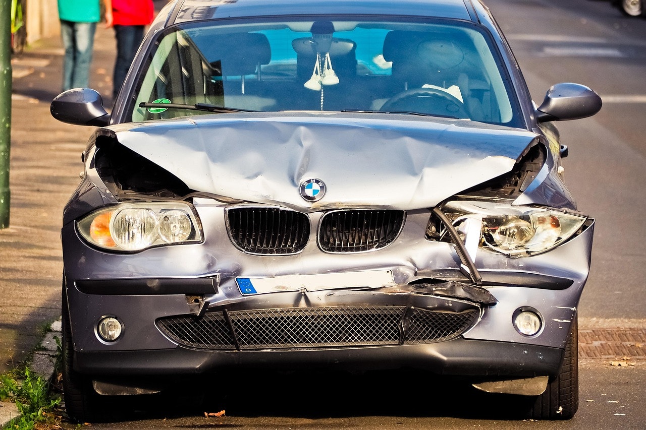 A person is taking a picture of a car with a cell phone.