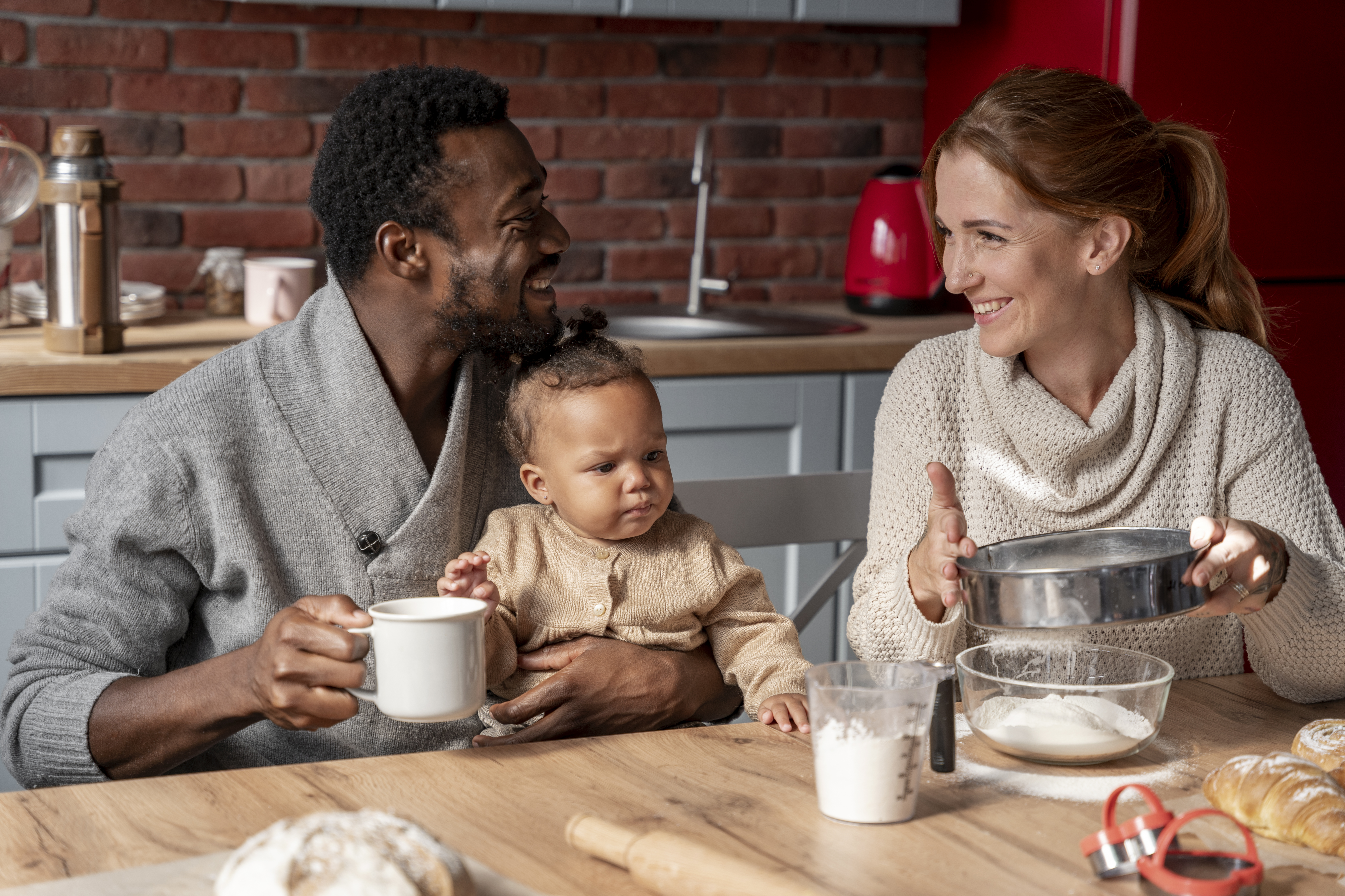 Family enjoying time together in the kitchen, with a baby and baking ingredients on the table
