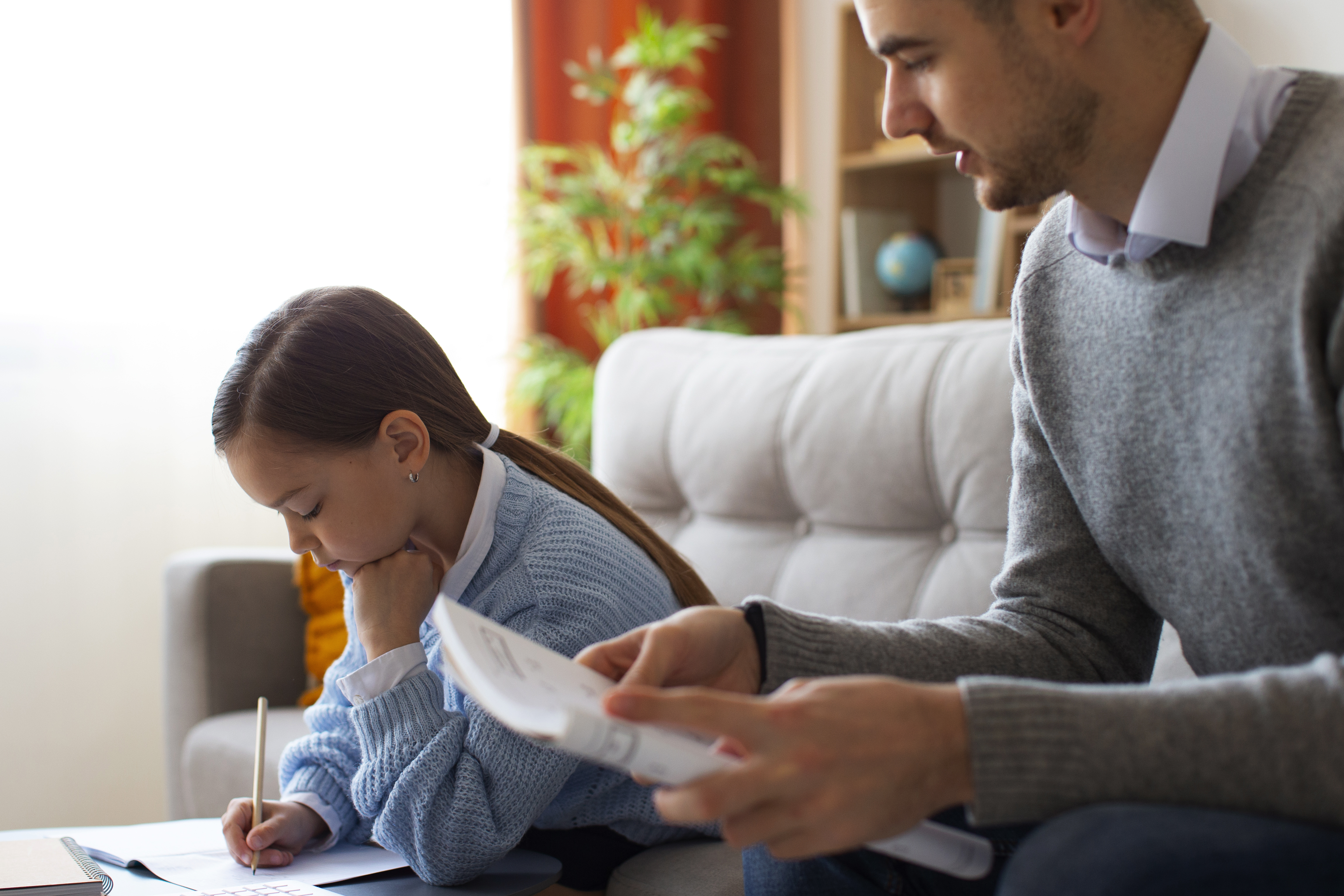 Father helping daughter with homework at home
