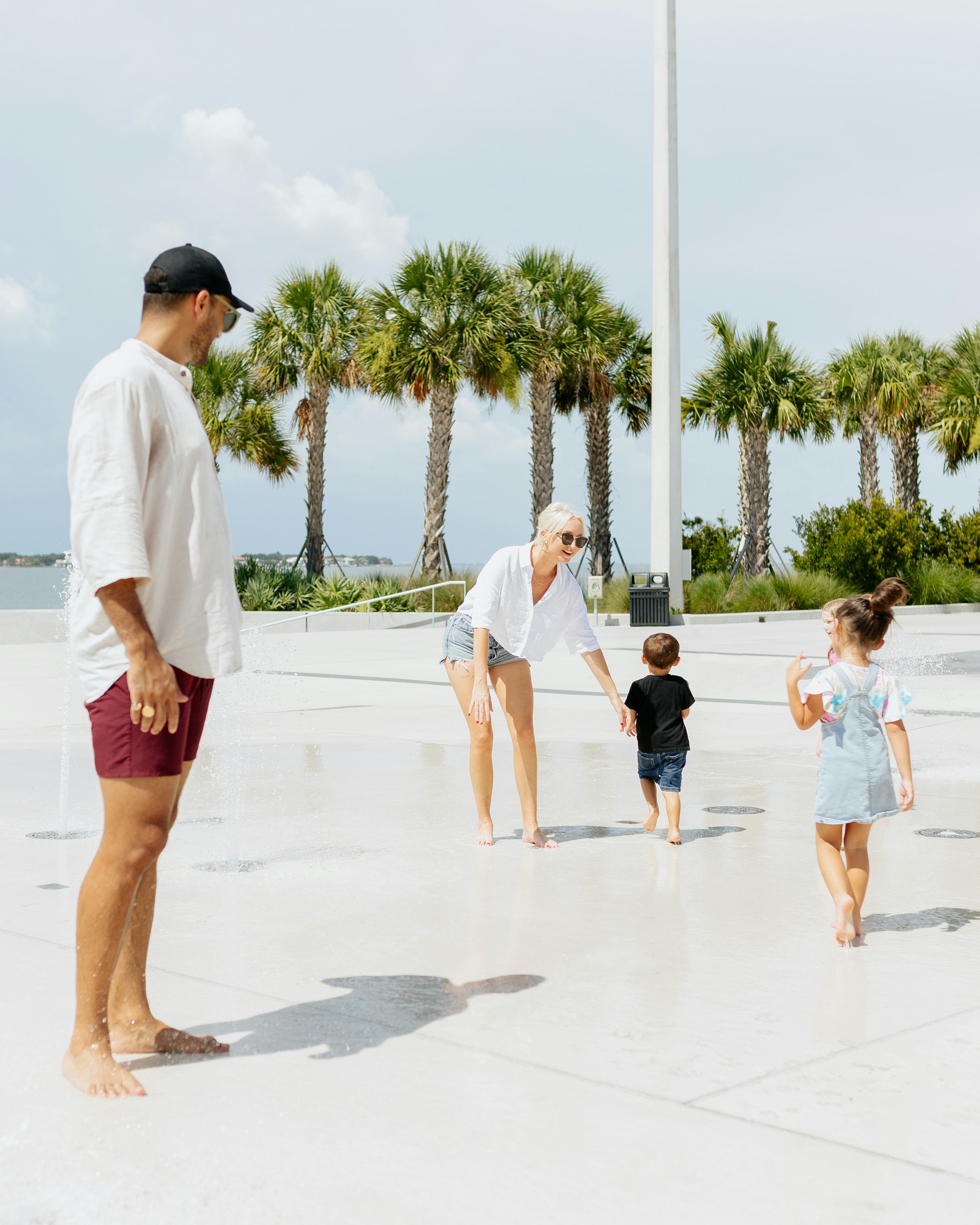 Family playing at a water park with palm trees in the background