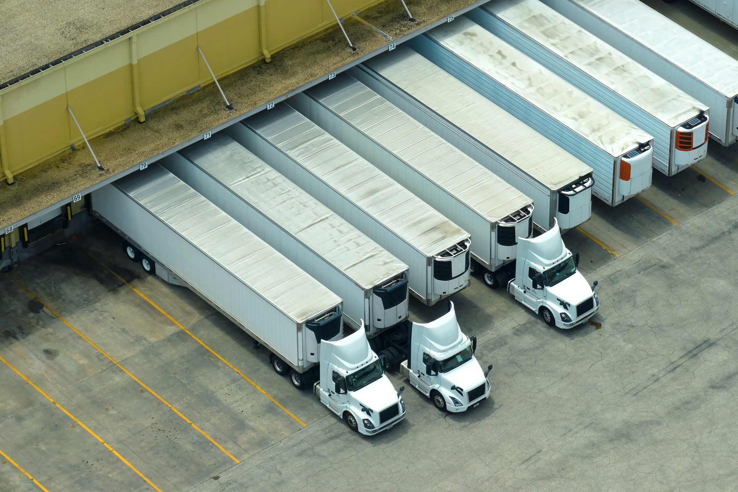 Aerial view of semi-trucks parked at a loading dock