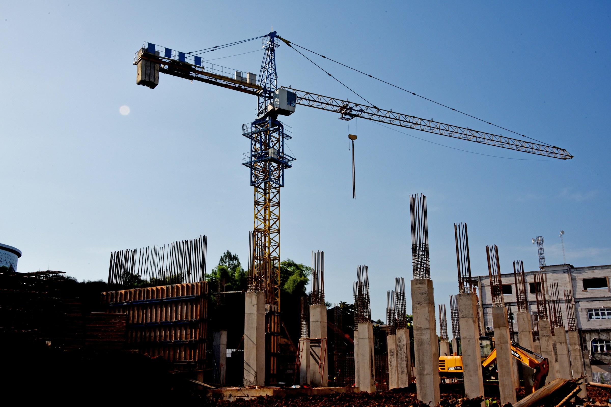 Construction site with a large crane and building framework under a clear blue sky