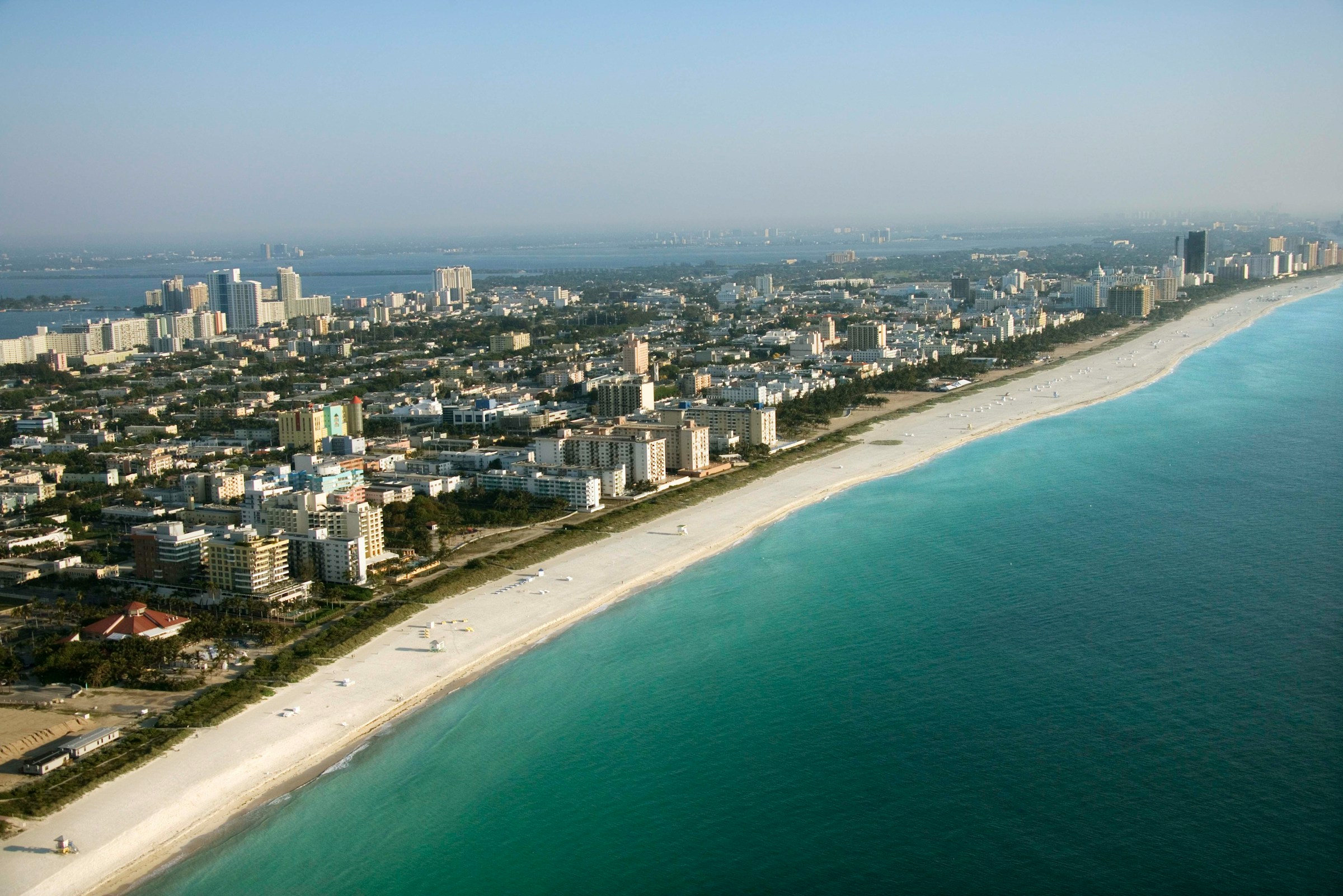 Aerial view of a coastal city with a long sandy beach and turquoise ocean