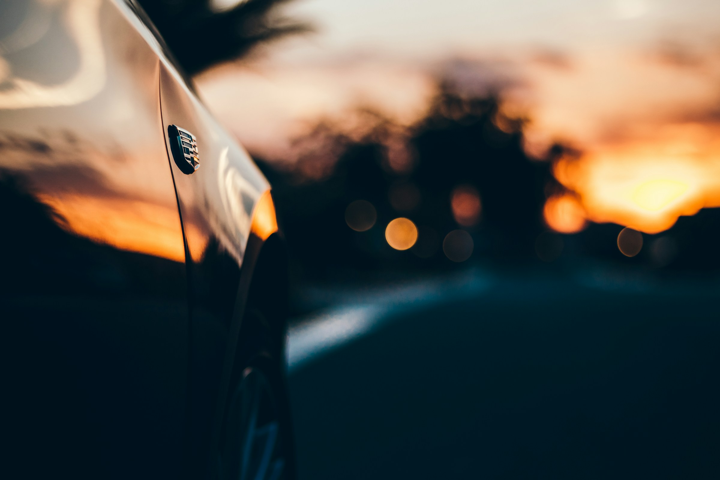 Close-up of a car with a sunset in the background