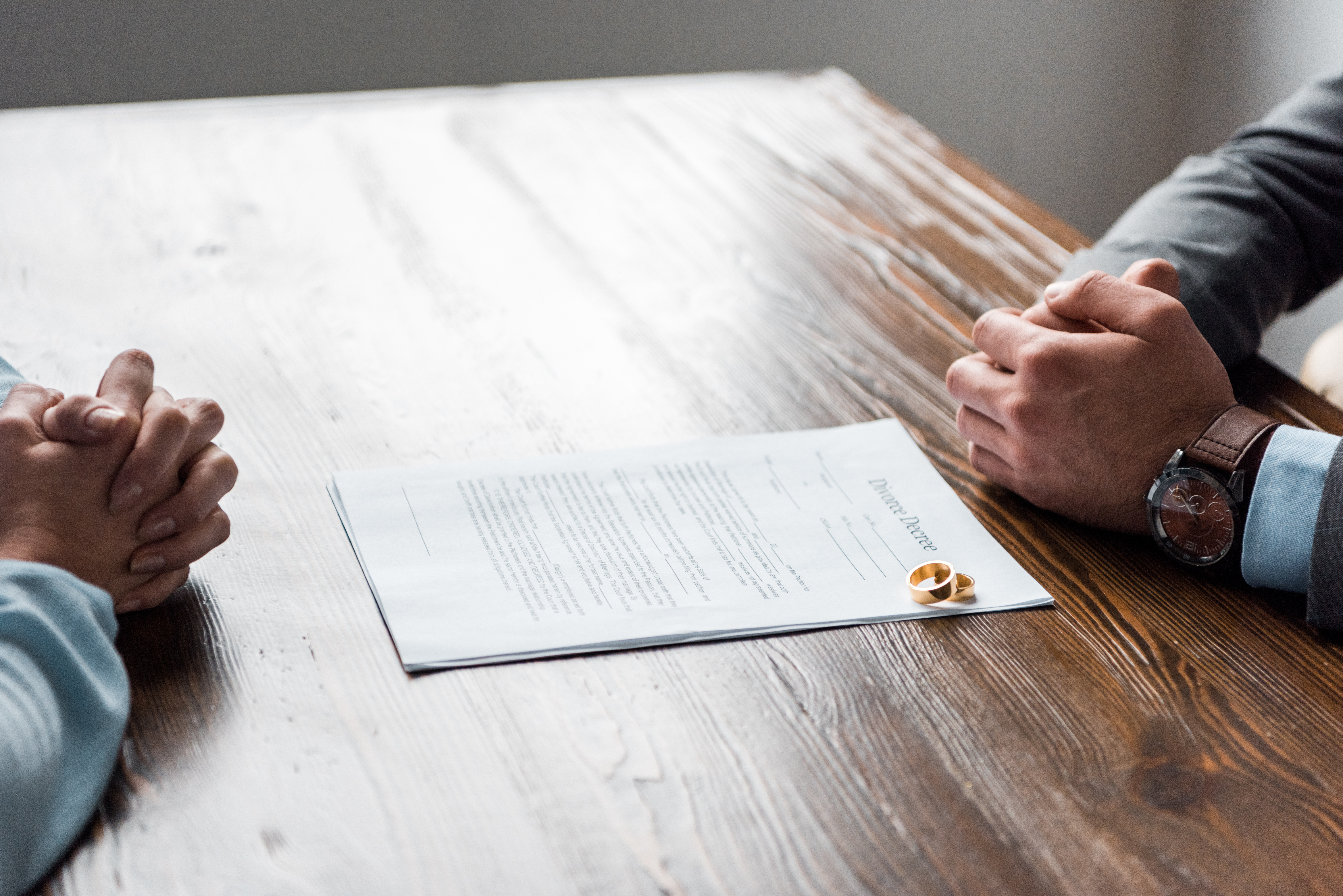 Family in kitchen: Father helps daughter with homework at table; siblings in background.