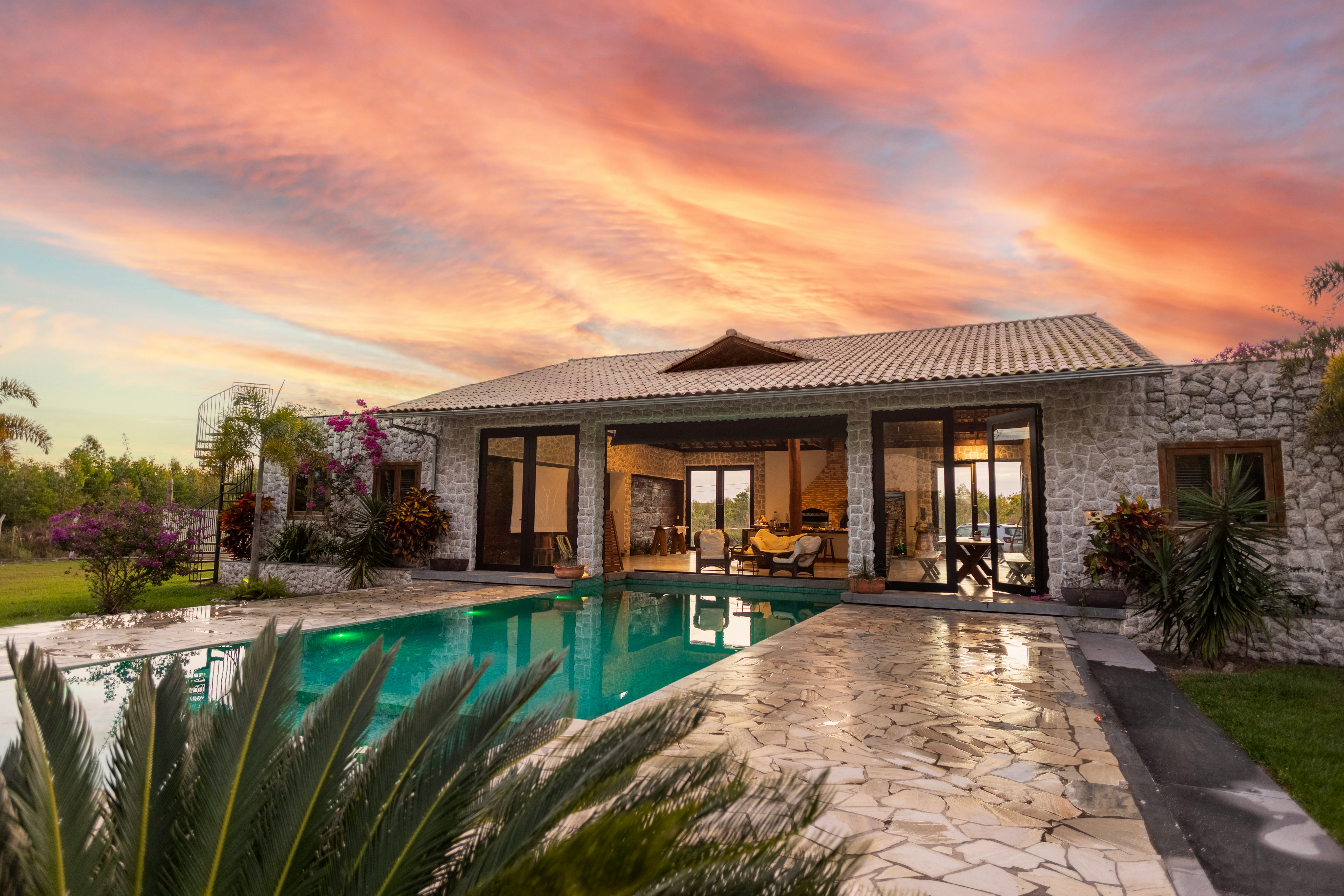 Luxury stone house with a pool at sunset