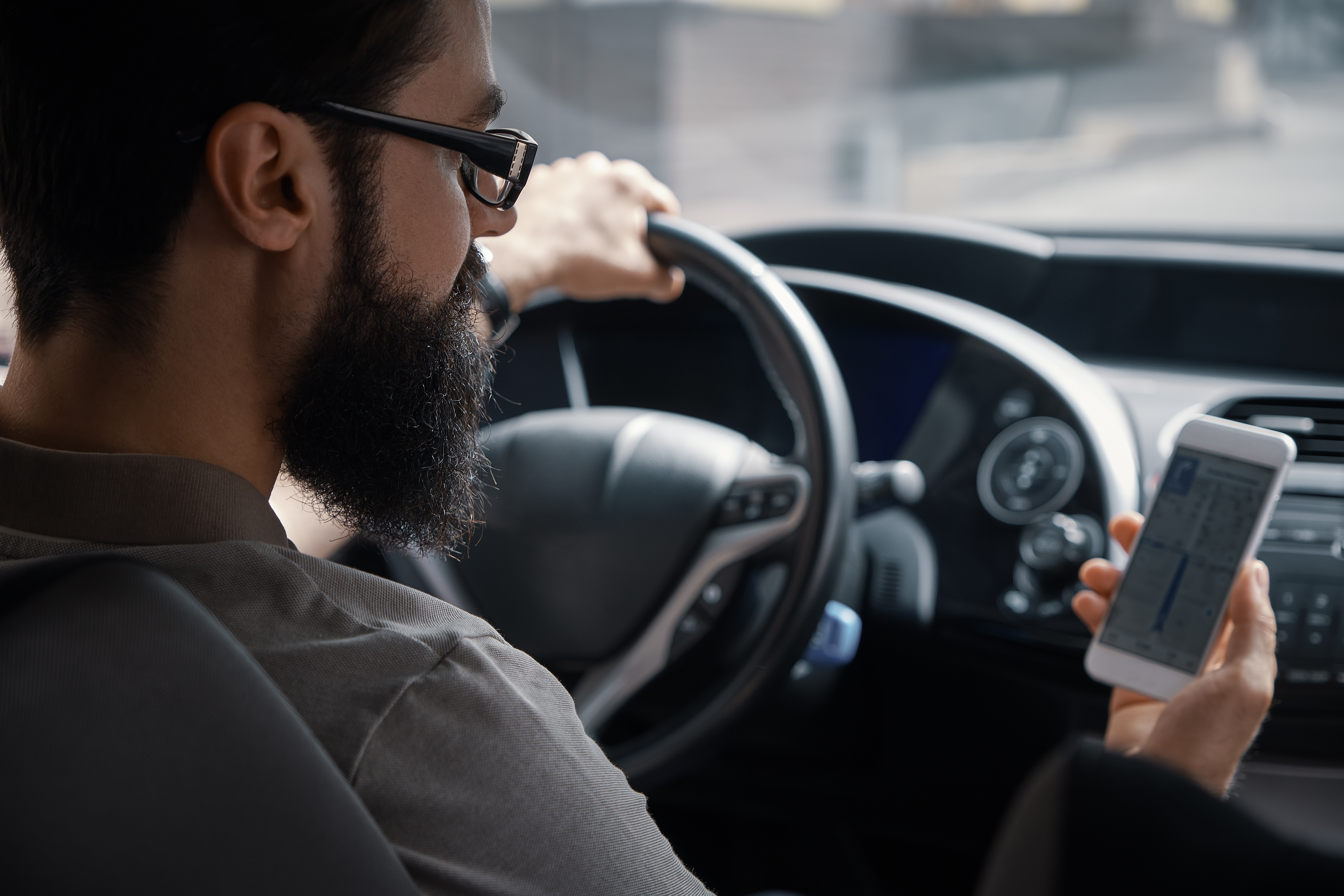 Driver looking at a smartphone while driving a car
