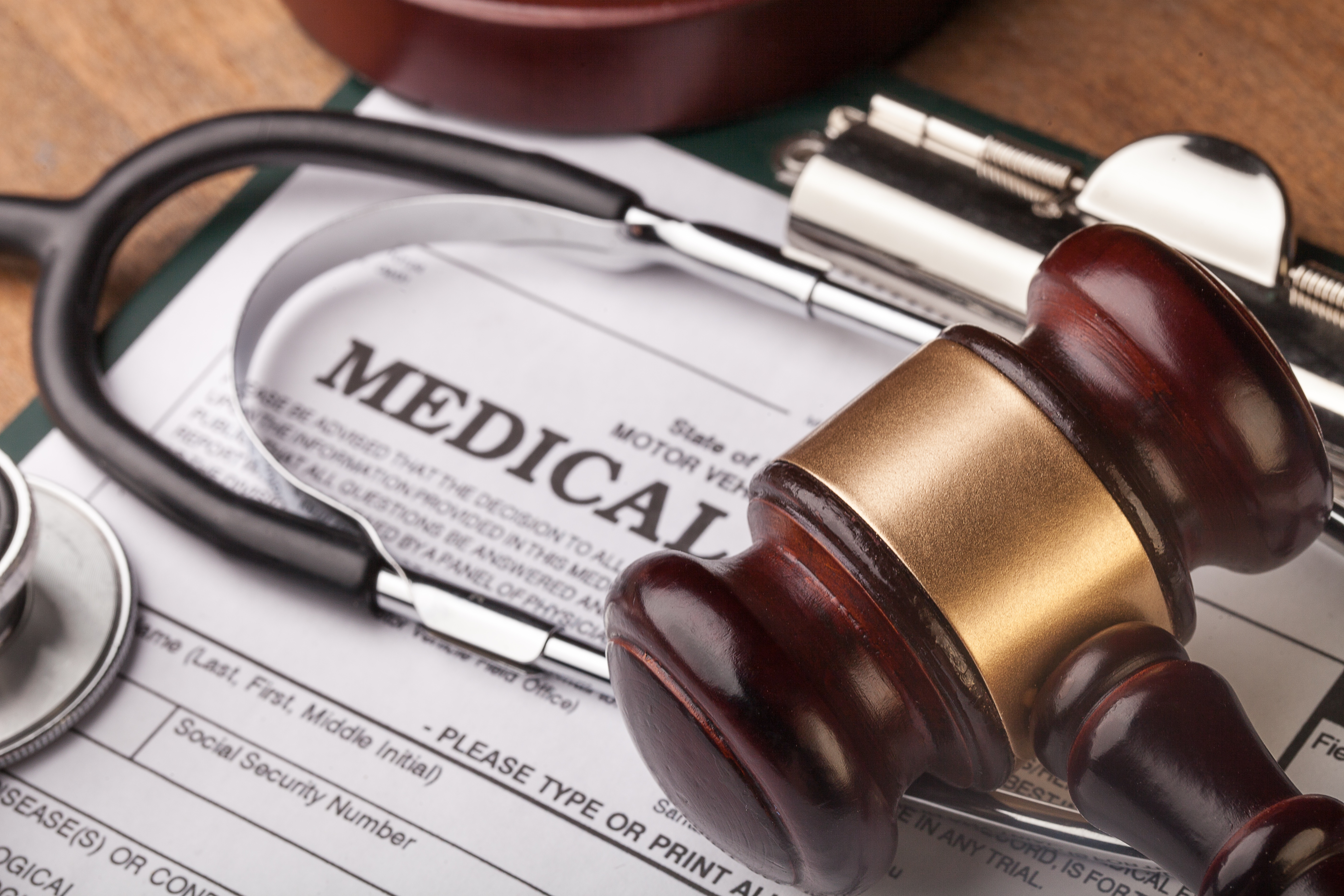 Gavel and stethoscope on medical form
