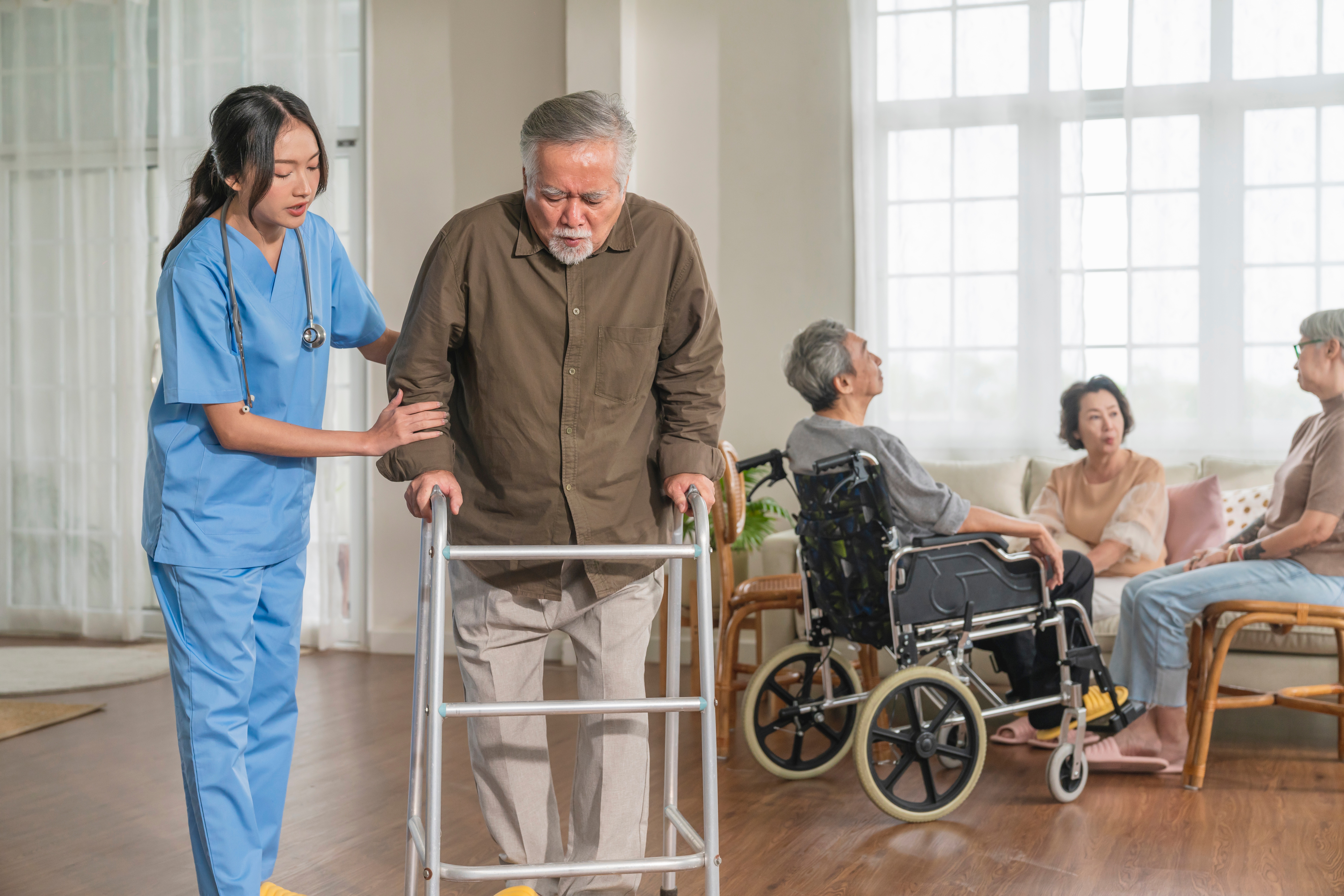 Healthcare worker assisting elderly man with a walker in a care facility