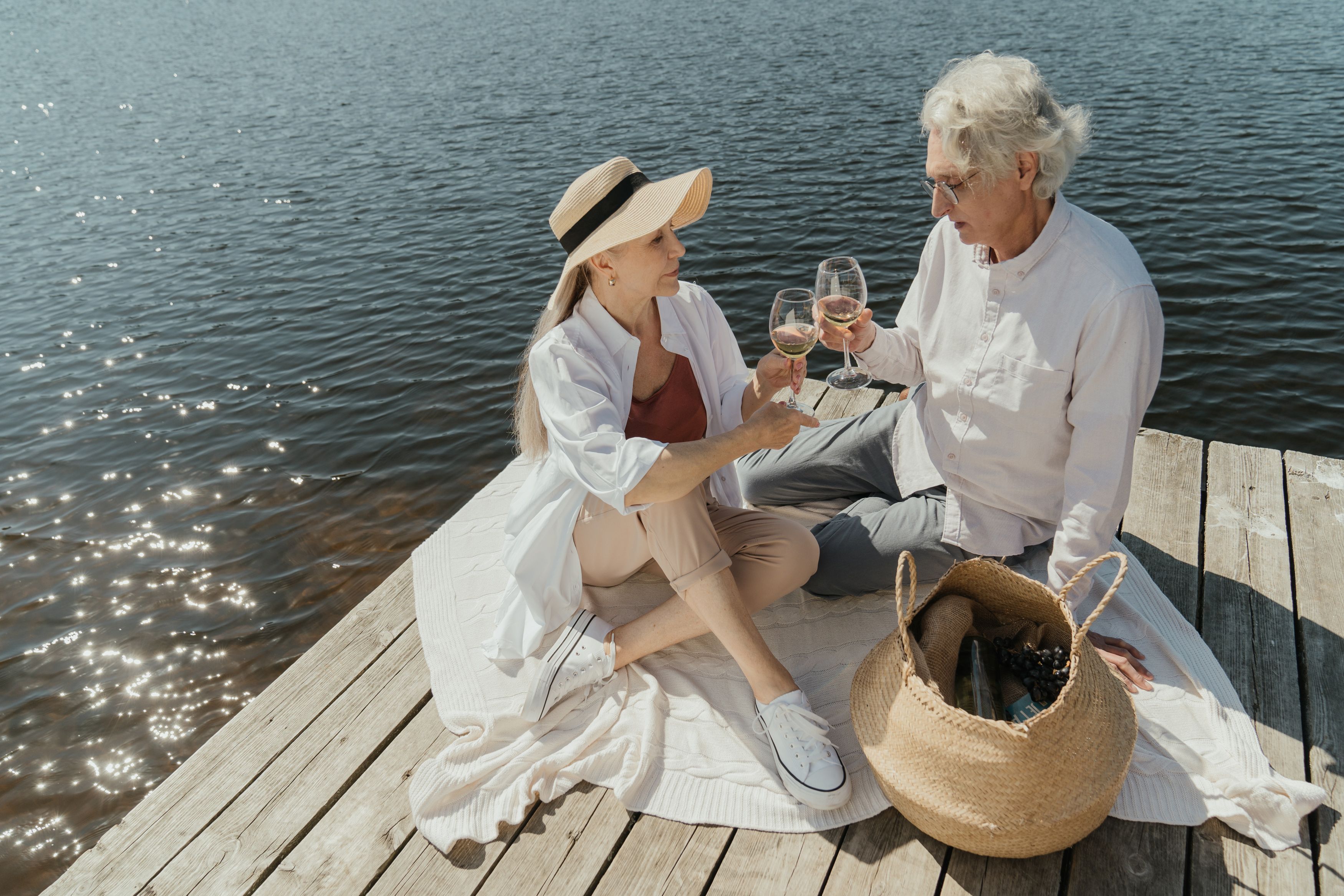 Senior couple enjoying a picnic on a dock by the water