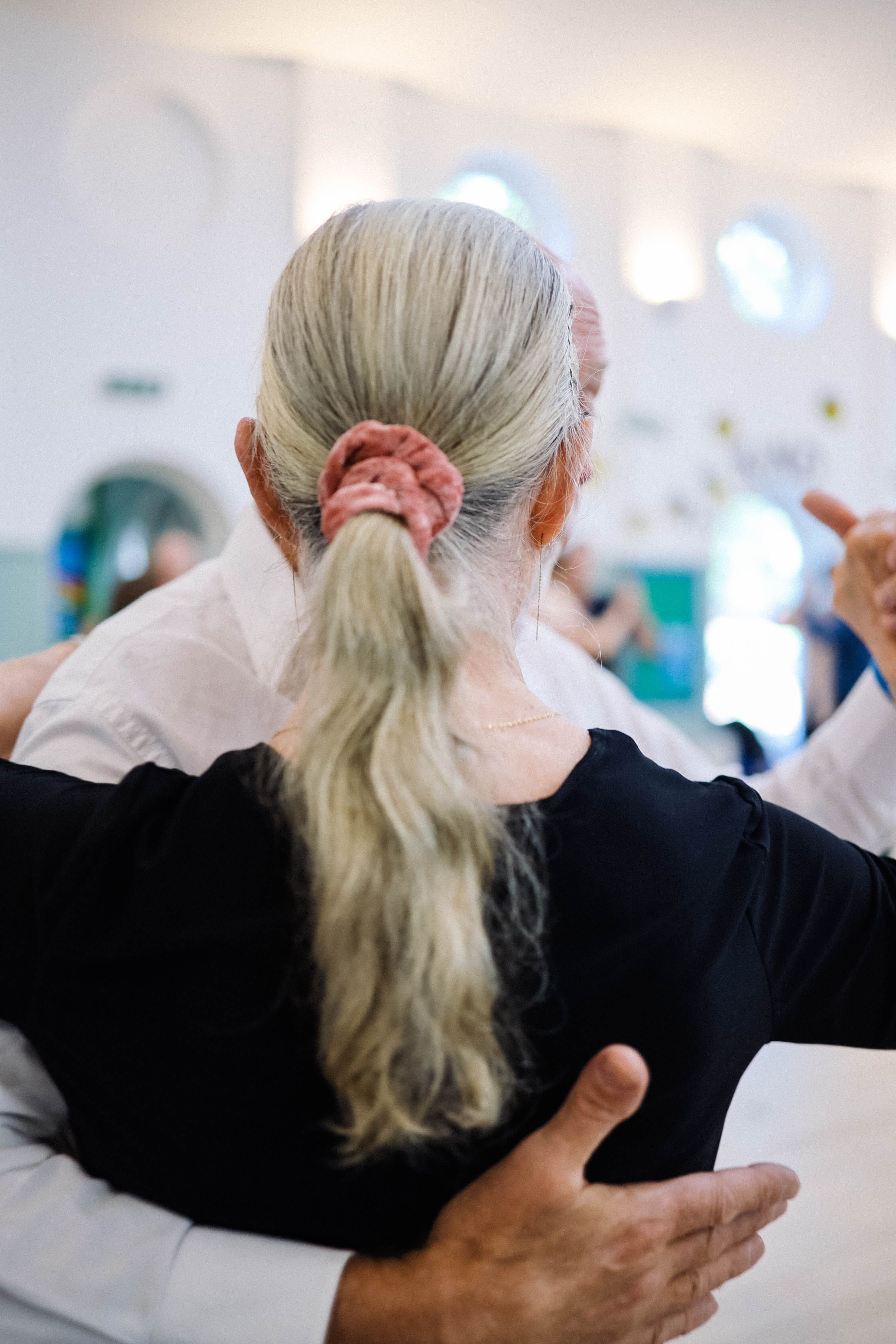 Older couple dancing closely in a bright room