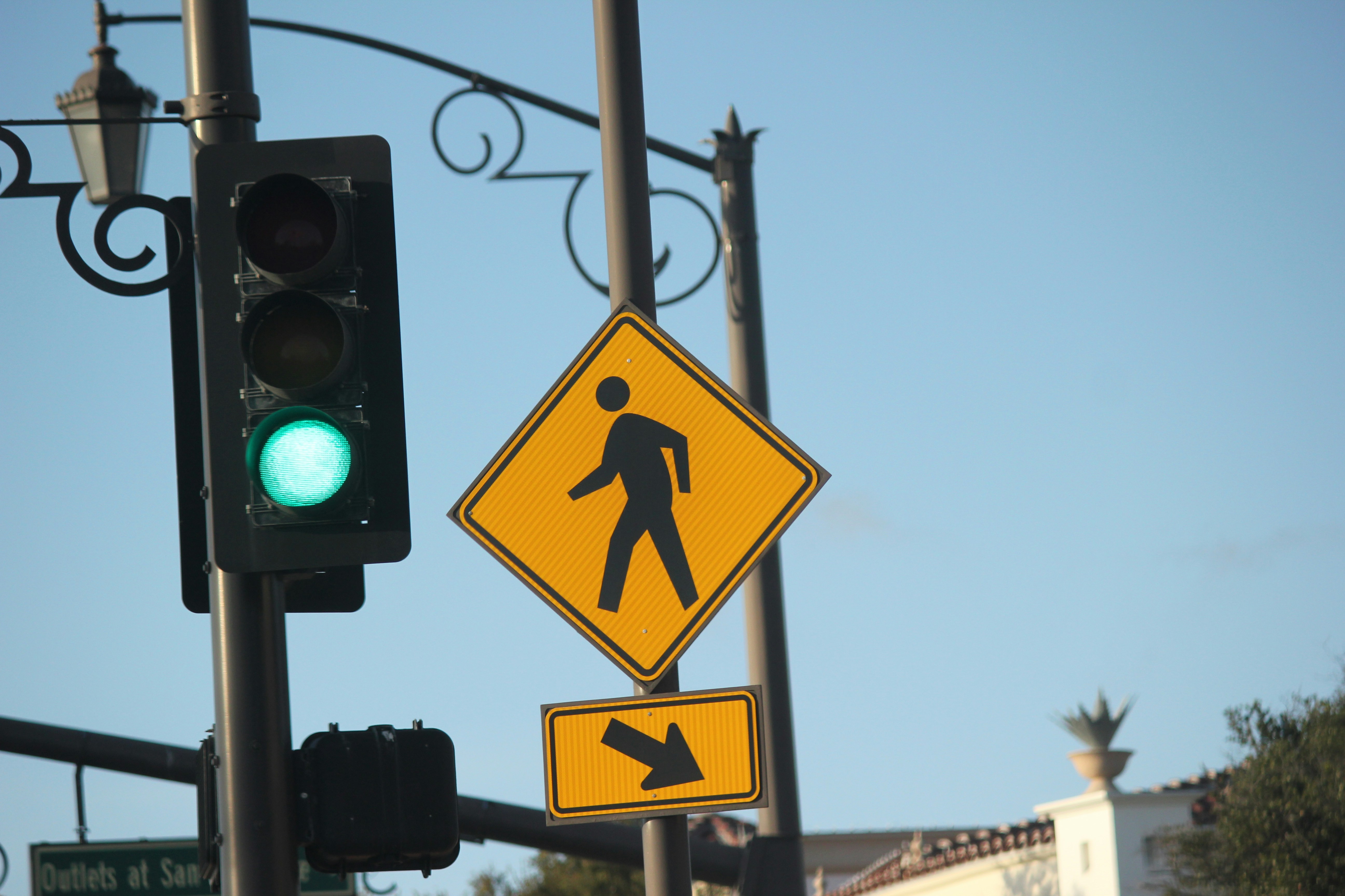 Traffic light with green signal and pedestrian crossing sign