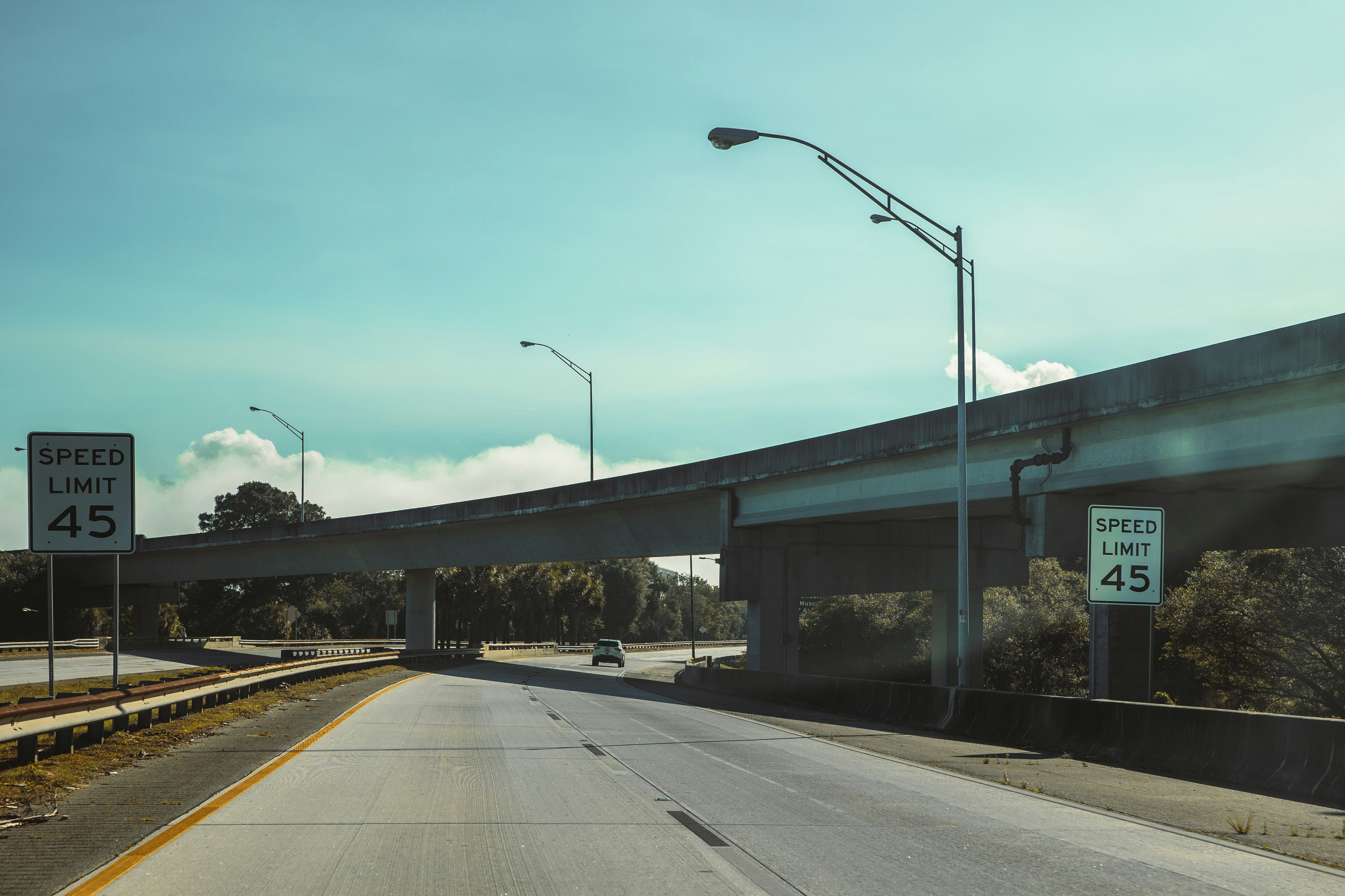 Empty highway with speed limit signs and overpass