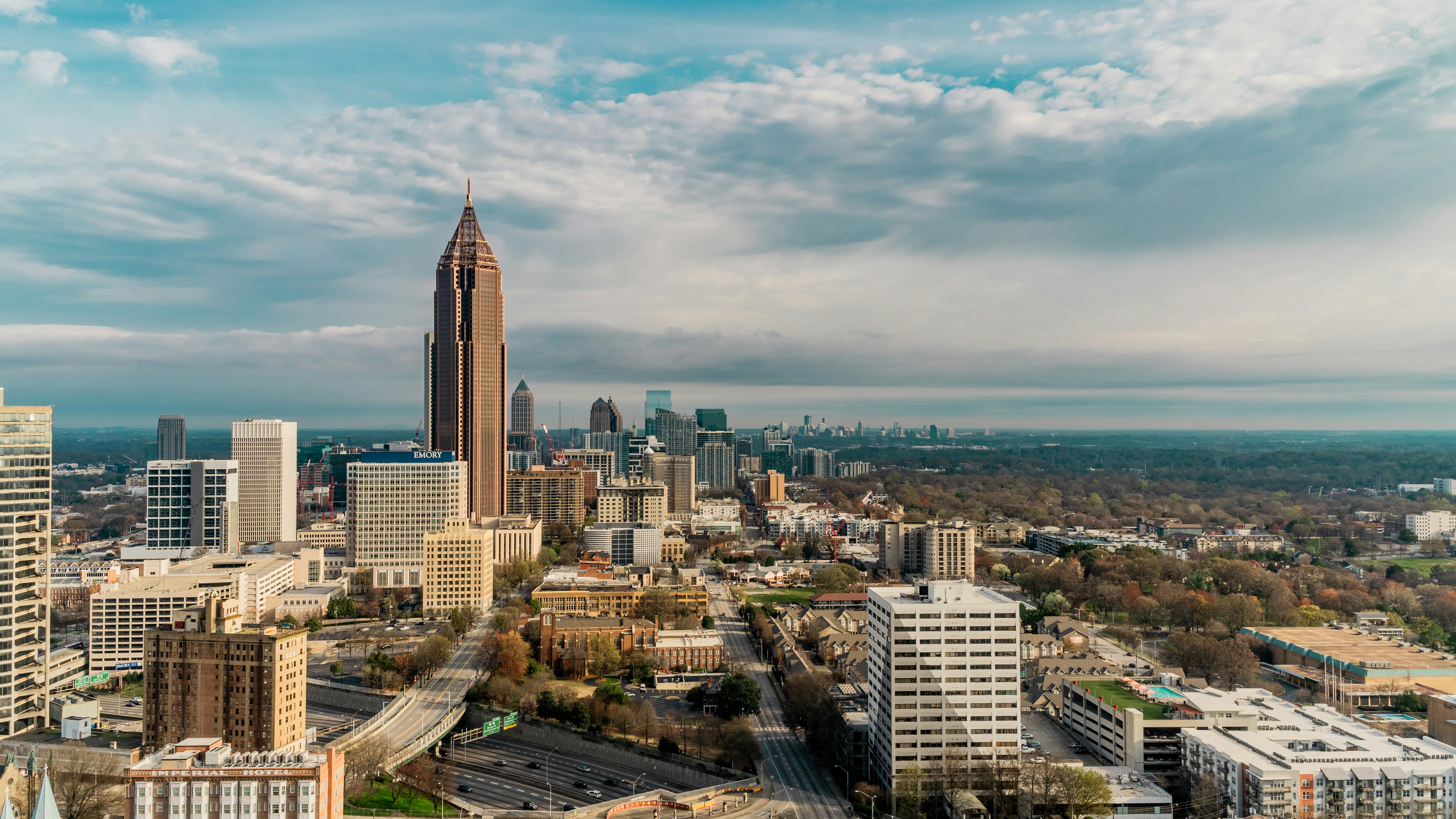 Aerial view of a cityscape with tall buildings and a cloudy sky