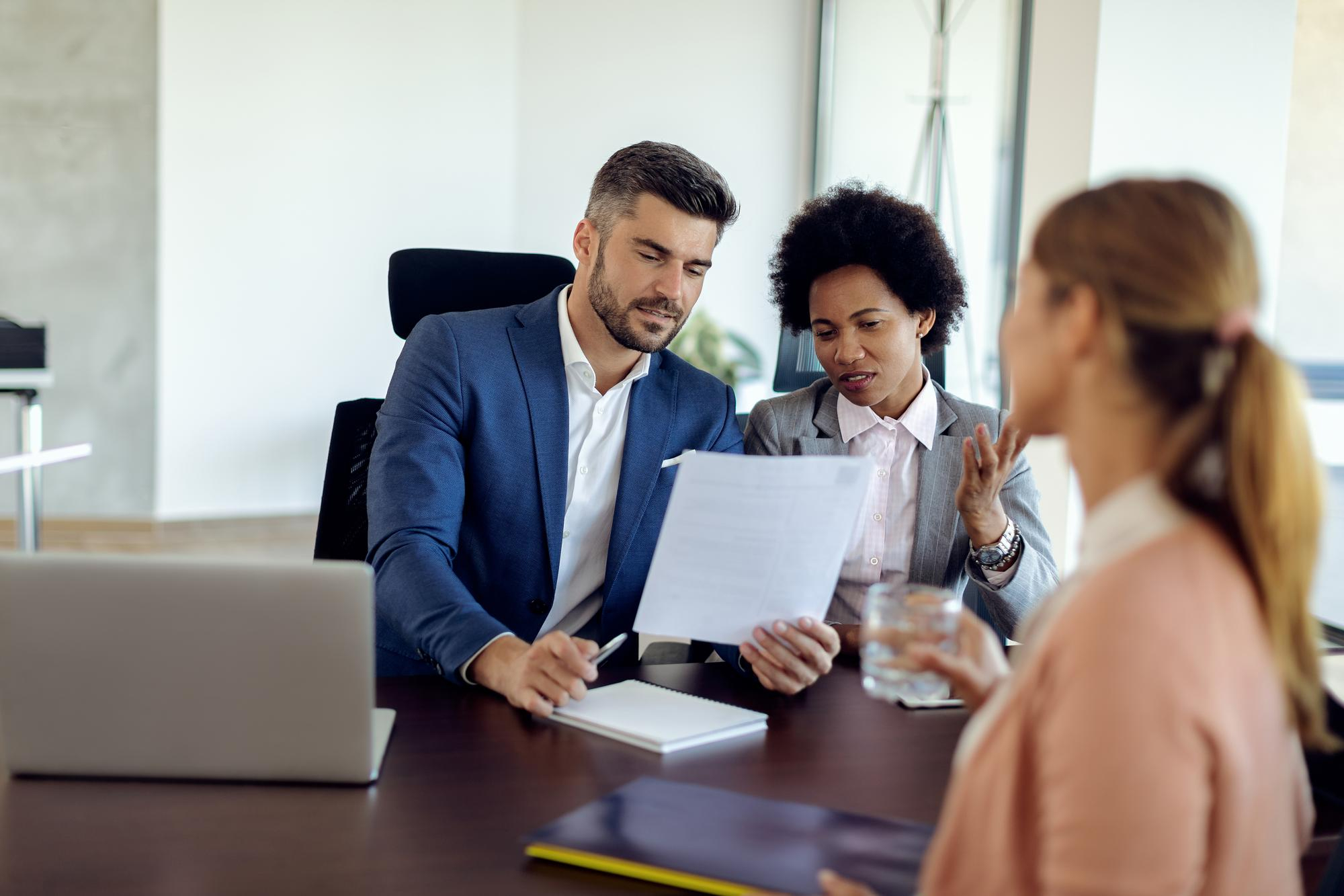 Business professionals discussing a document in an office setting