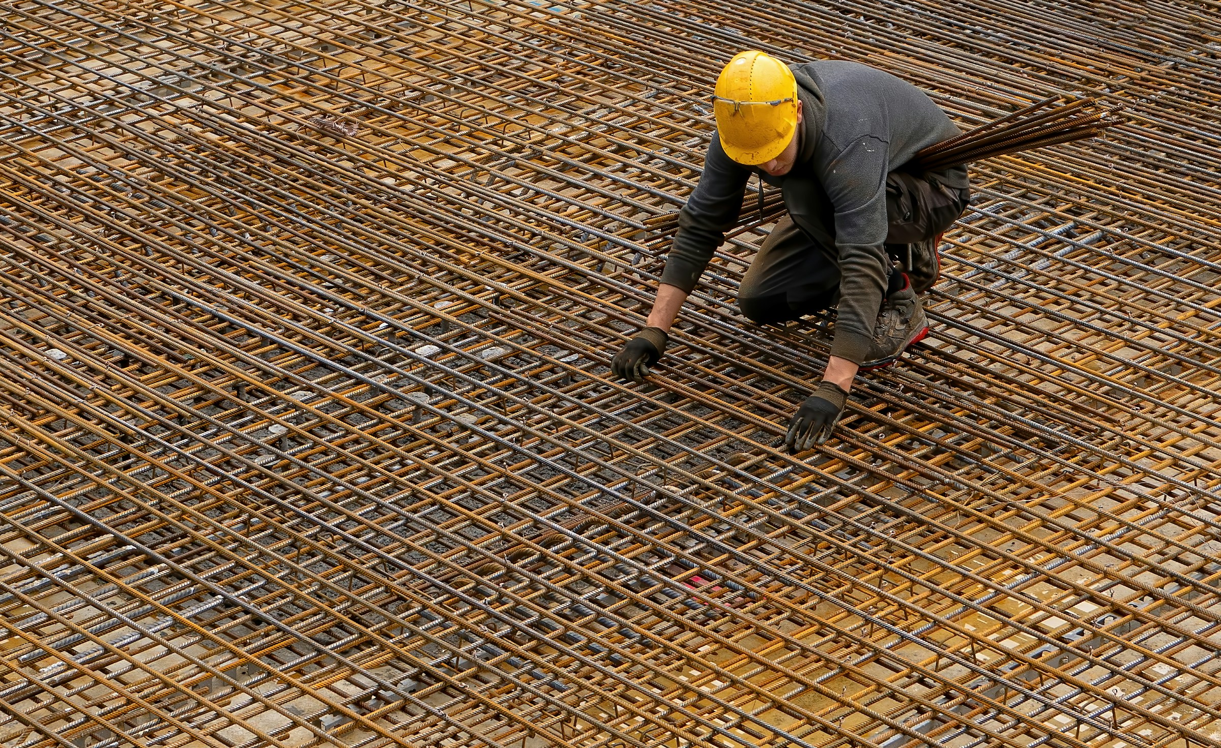 Construction worker installing steel rebar on a construction site