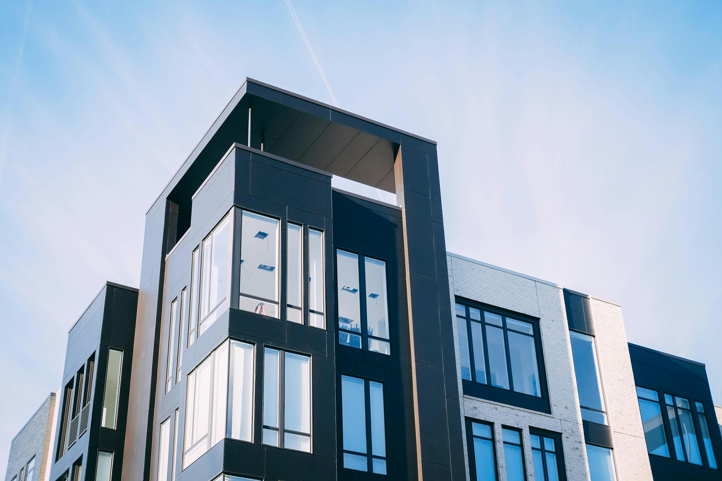Modern apartment building with large windows against a blue sky