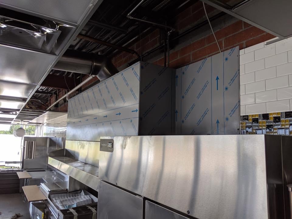 Commercial kitchen with stainless steel appliances and ventilation system