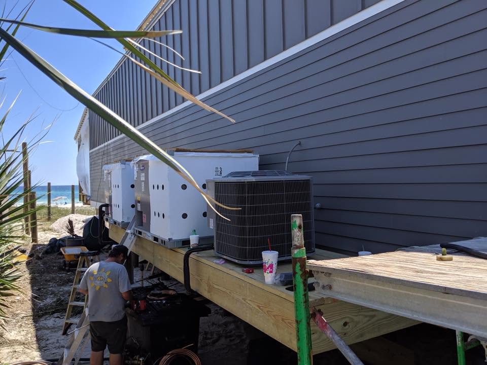 Air conditioning units installed on the side of a building near the beach