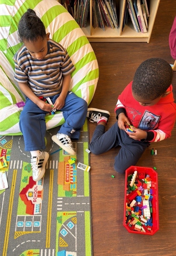 A group of children are sitting on the ground playing with clay.