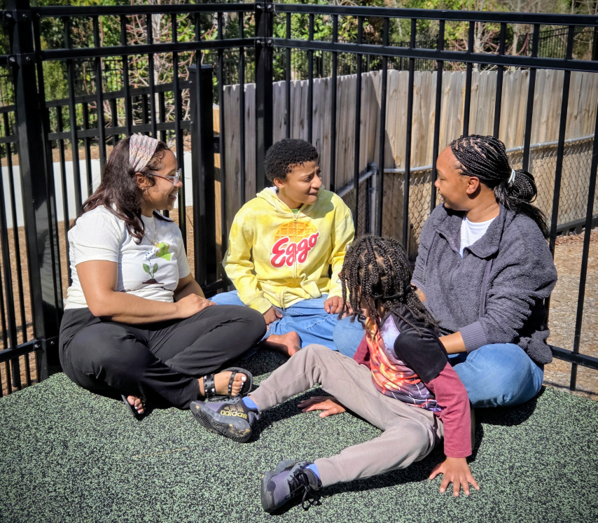 A group of children are sitting on the ground playing with clay.